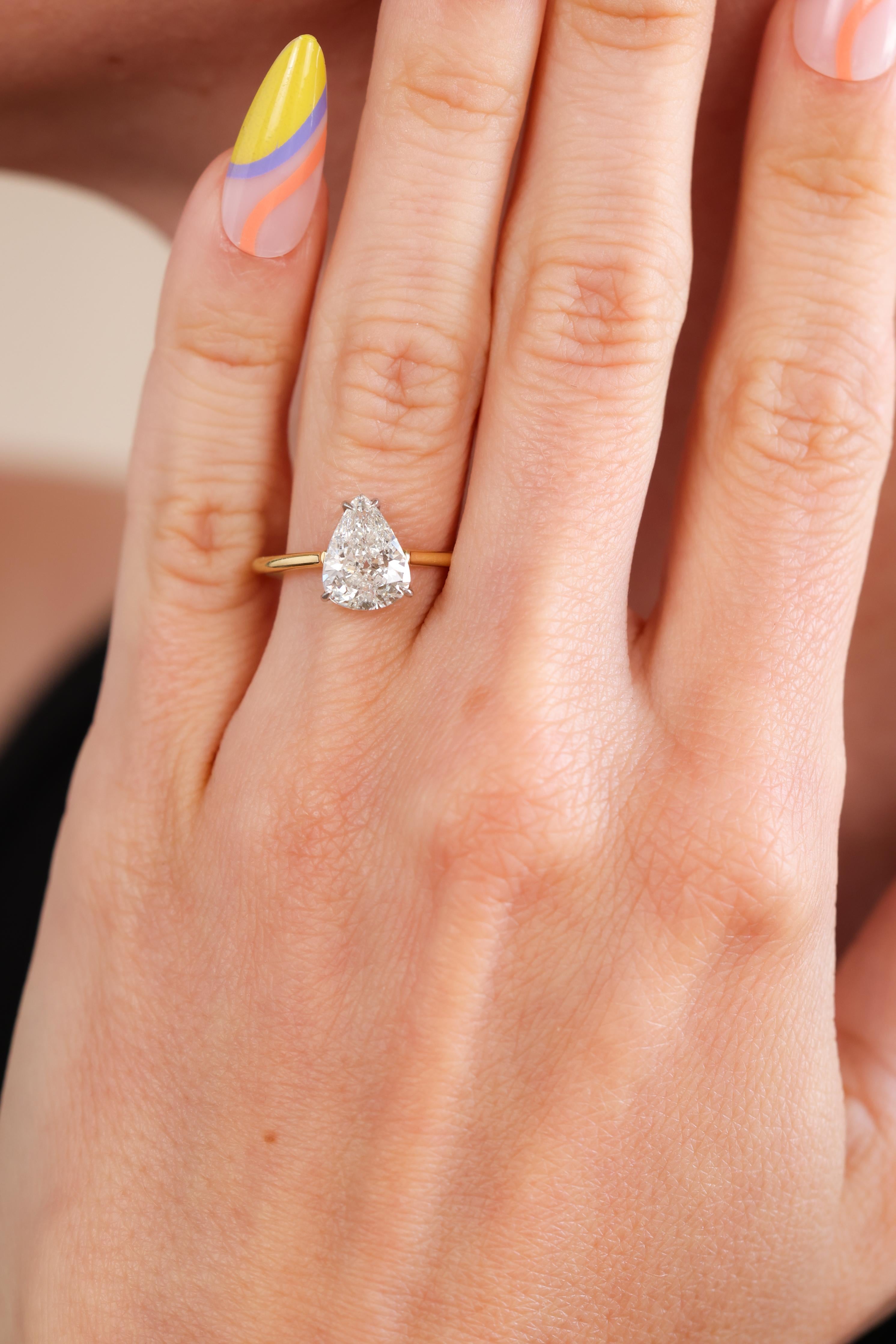 This is a timeless, newly crafted diamond solitaire engagement ring. The 18k yellow gold ring centers a gorgeous, platinum prong-set diamond accompanied by a GIA Diamond Grading Report stating the 2.01ct Pear Brilliant Cut diamond is graded I color
