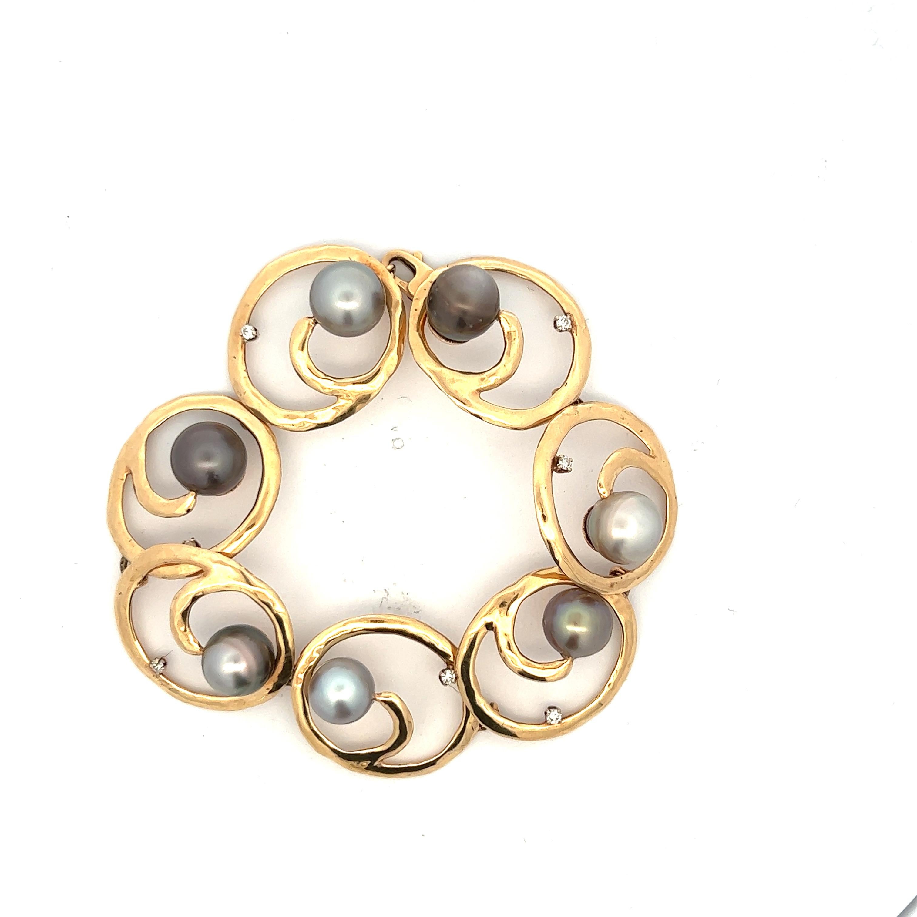 South Sea pearl and diamond bracelet fashioned in 14 karat yellow gold. The bracelet features open circle links with 7 round brilliant cut diamonds and 7 South Sea pearls. The diamonds weigh approximately .28 CTW and the pearls measure 9.5-10.5mm in
