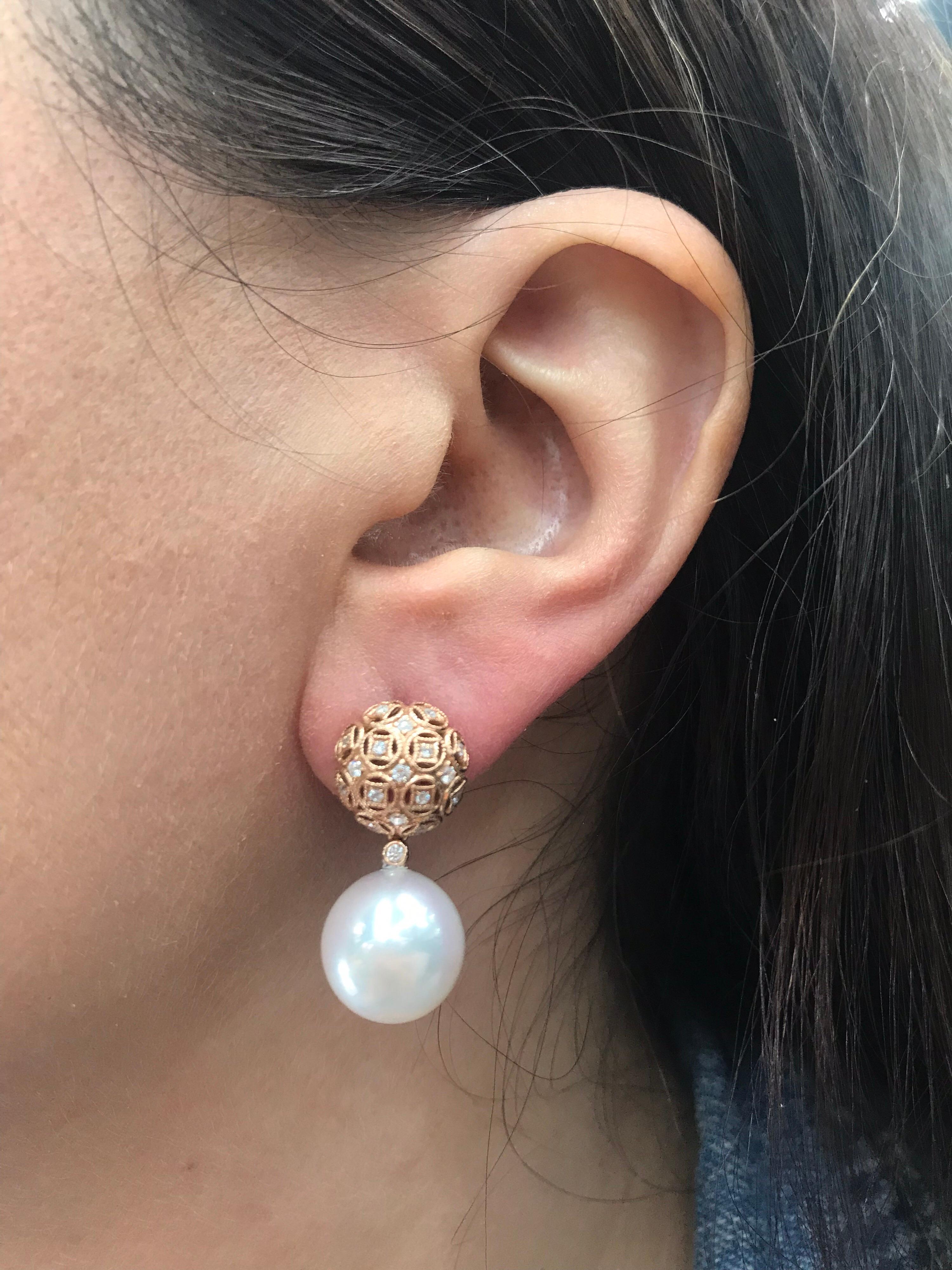 18K Rose gold drop earrings featuring two South Sea Pearls measuring 13-14 mm and 36 round brilliants weighing 0.30 carats in a miligrain motif. 
