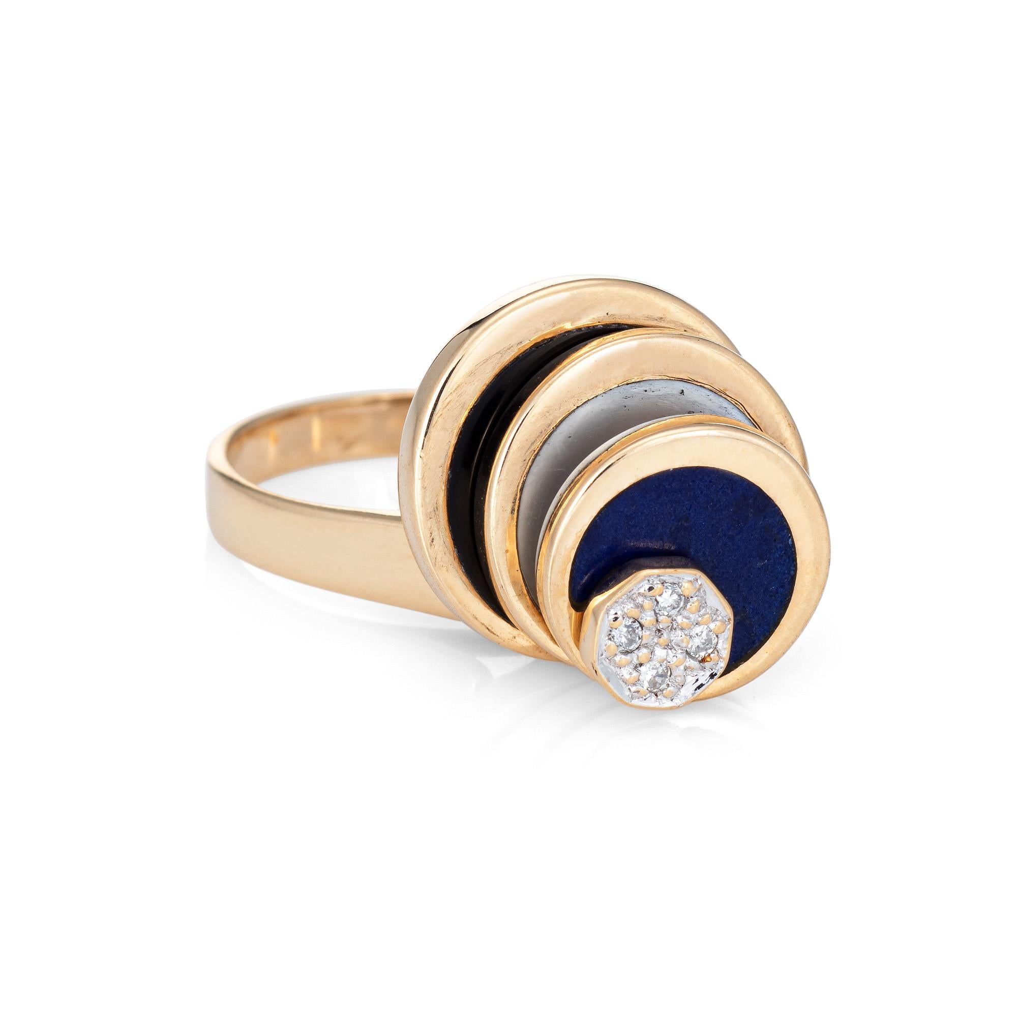 Stylish vintage diamond spinning ring (circa 1970s to 1980s) crafted in 14 karat yellow gold. 

Diamonds total an estimated 0.02 carats (estimated at H-I color and I1 clarity). Lapis lazuli, mother-of-pearl and onyx are inlaid into the graduated