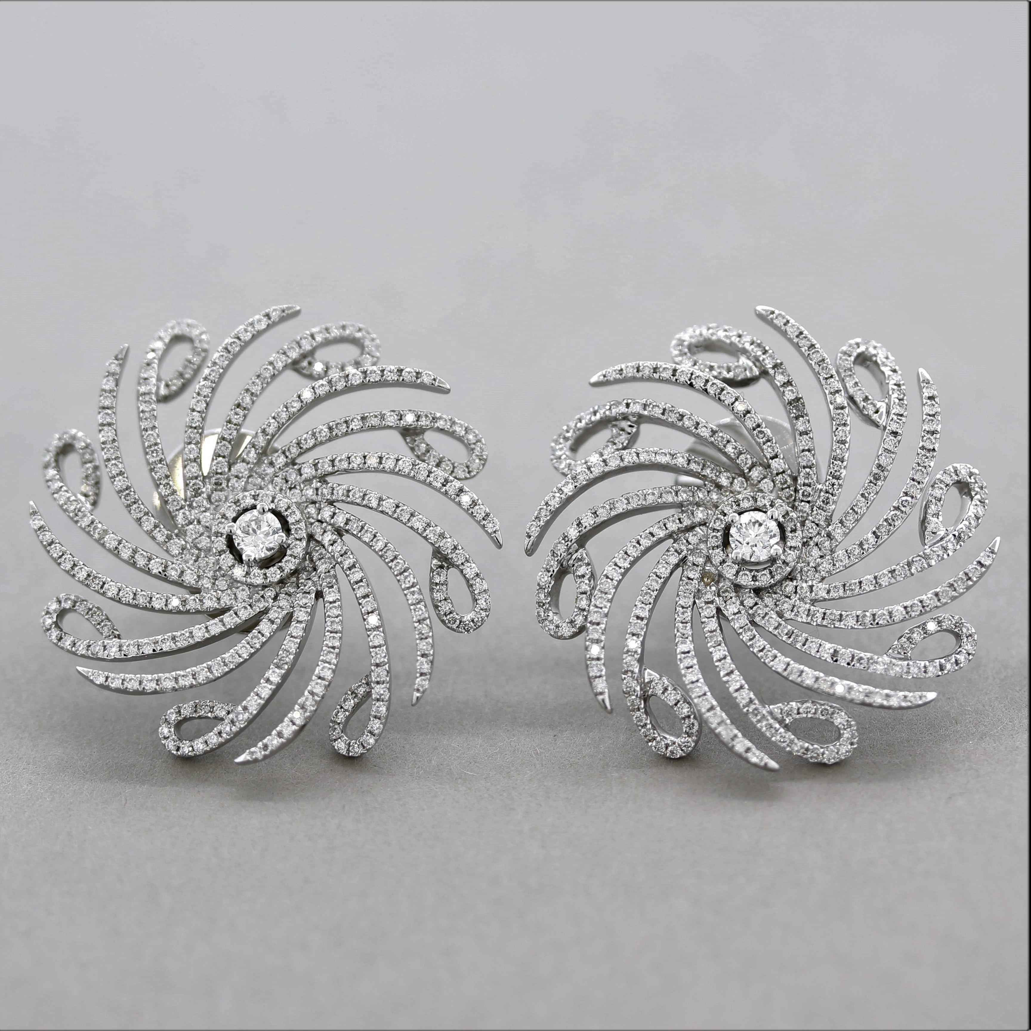 A stylish pair of diamond gold earrings! They feature 2.42 carats of round brilliant-cut diamonds set in a spiral pattern along with a larger diamond in the center of each flower. Made in 18k white gold, this stylish pair of flower earrings will