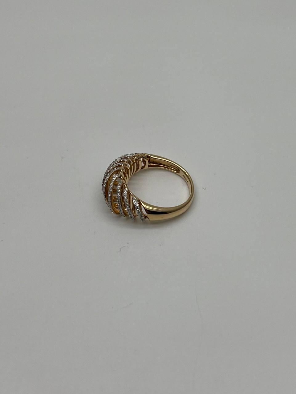 This elegant piece, crafted in 14K gold, features a dynamic design with a series of spiraling bands adorned with shimmering diamonds. The intricate arrangement creates a sense of movement and fluidity, capturing light from every angle.
The ring's