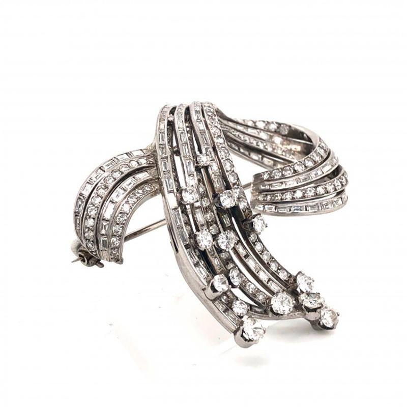 A vintage diamond set spray brooch, alternating rows of eight-cut and baguette cut diamonds, in a sweeping loop design, mounted in platinum. Estimated total diamond weight 4.50ct, measures approximately 55 x 48mm