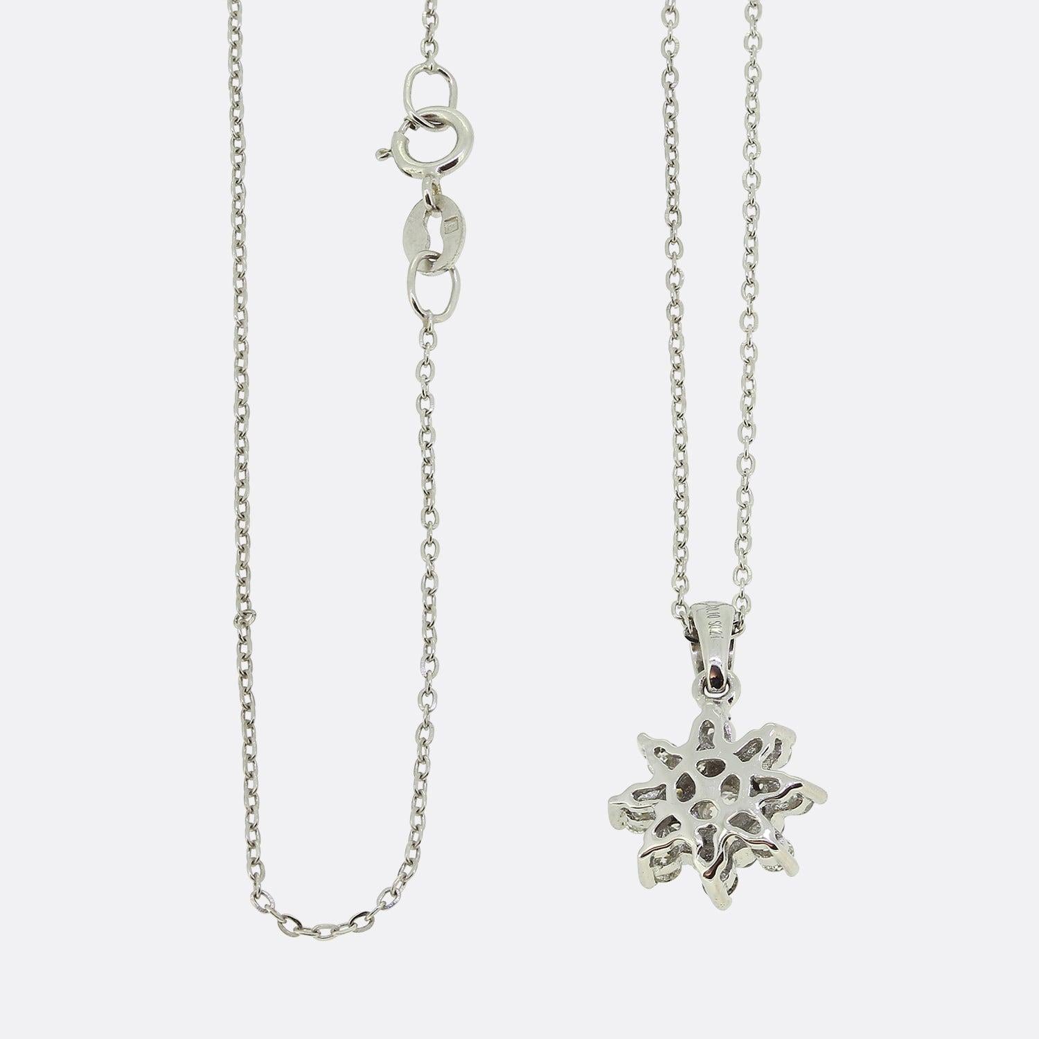 Qui abbiamo un ciondolo a stella con diamante in oro bianco 14ct. Il pendente presenta un diamante centrale dal taglio inedito, circondato da altri 16 diamanti rotondi dal taglio brillante. Il ciondolo si trova su una catena in oro 14ct da 18