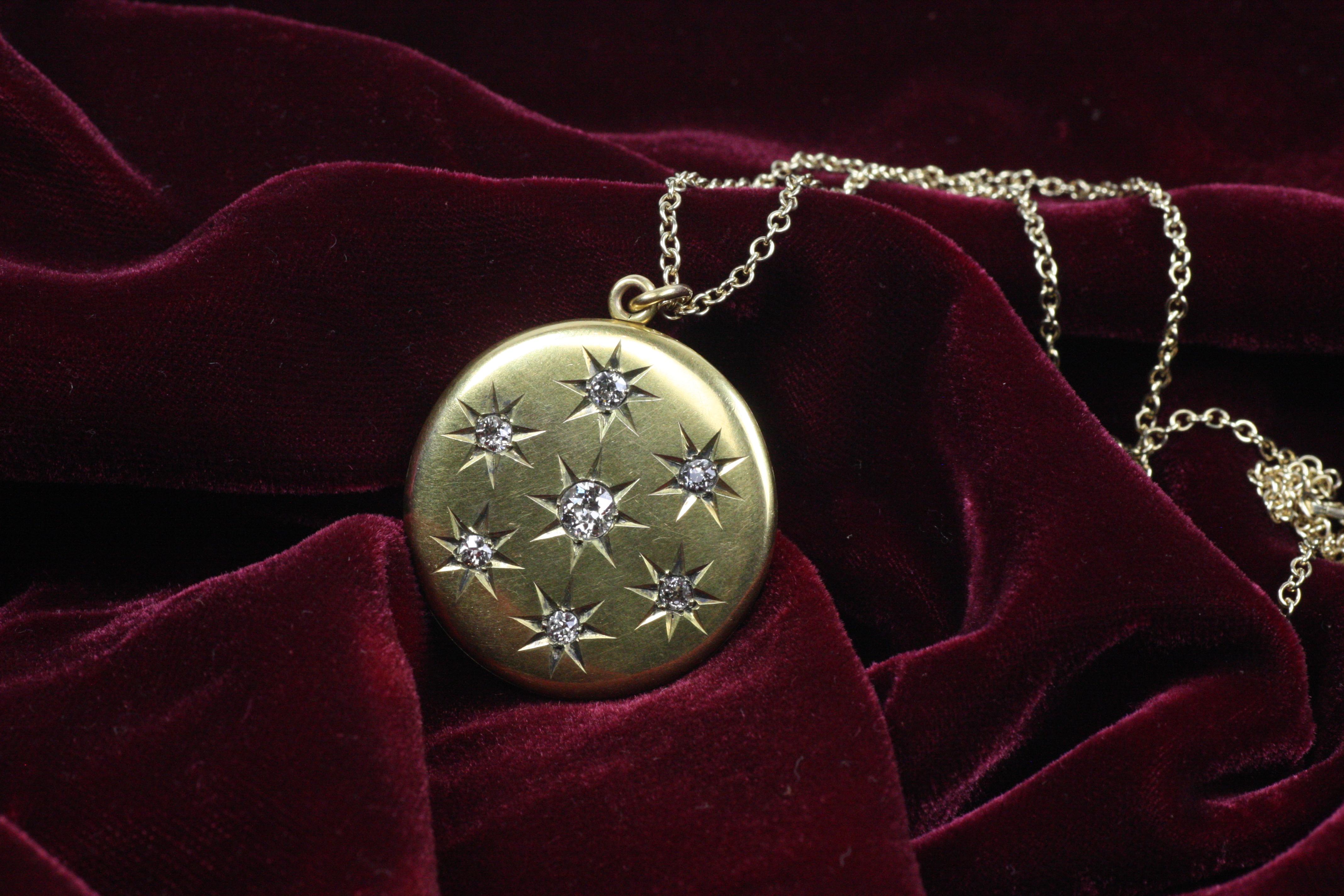 Relicario circular antiguo engastado con siete diamantes naturales talla mina antigua, con un total de 1,45 qt, en un engaste de estrella tallada a mano en oro amarillo de 14k. Este precioso reloj, de hacia 1900, tiene un hueco para dos fotos, una a