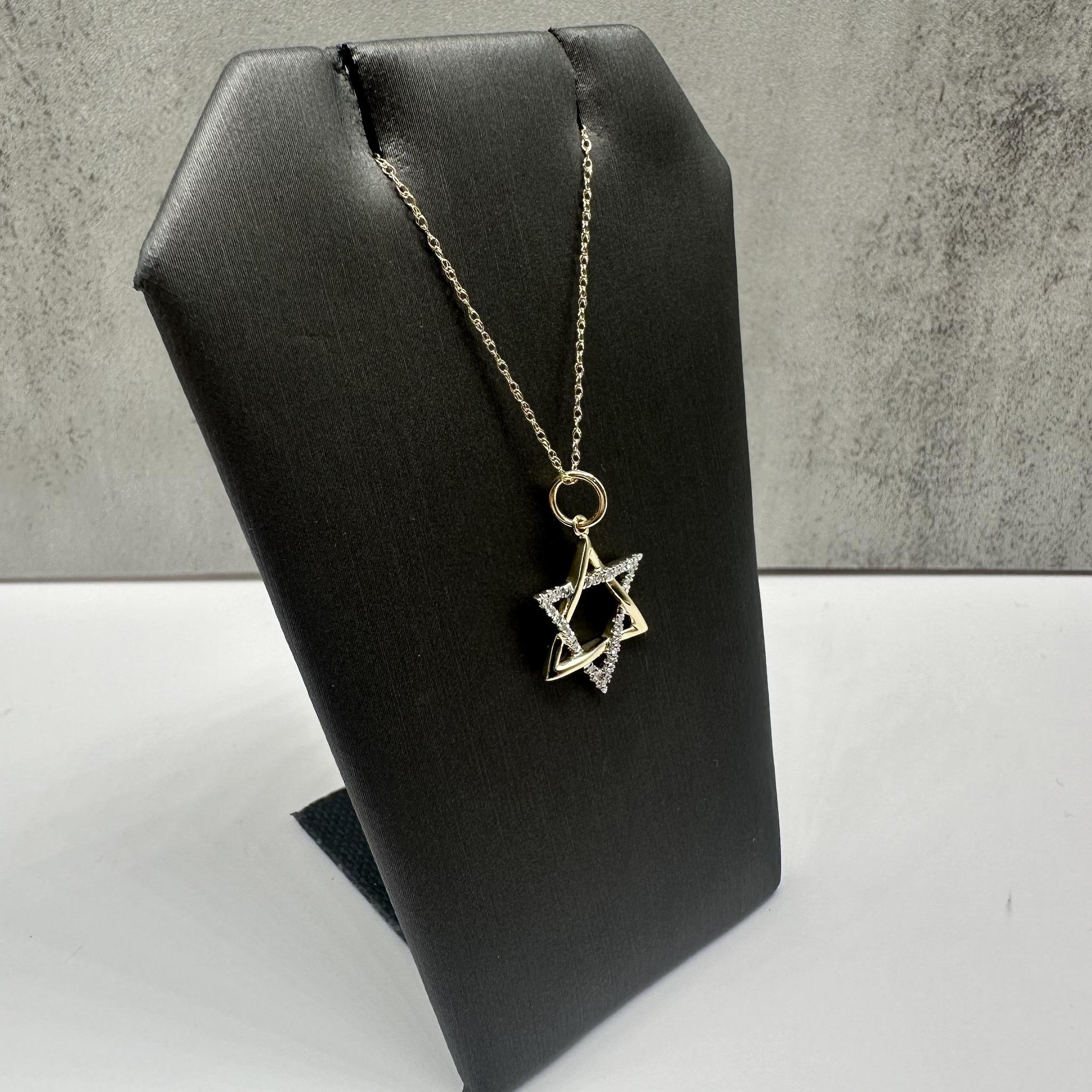 This elegant Diamond Star of David Necklace in 10kt yellow gold features 0.10ctw of natural GH SI2-I1 round single-cut diamonds, adding a subtle sparkle to the meaningful design. The 18-inch length fits comfortably around the neck, and the spring