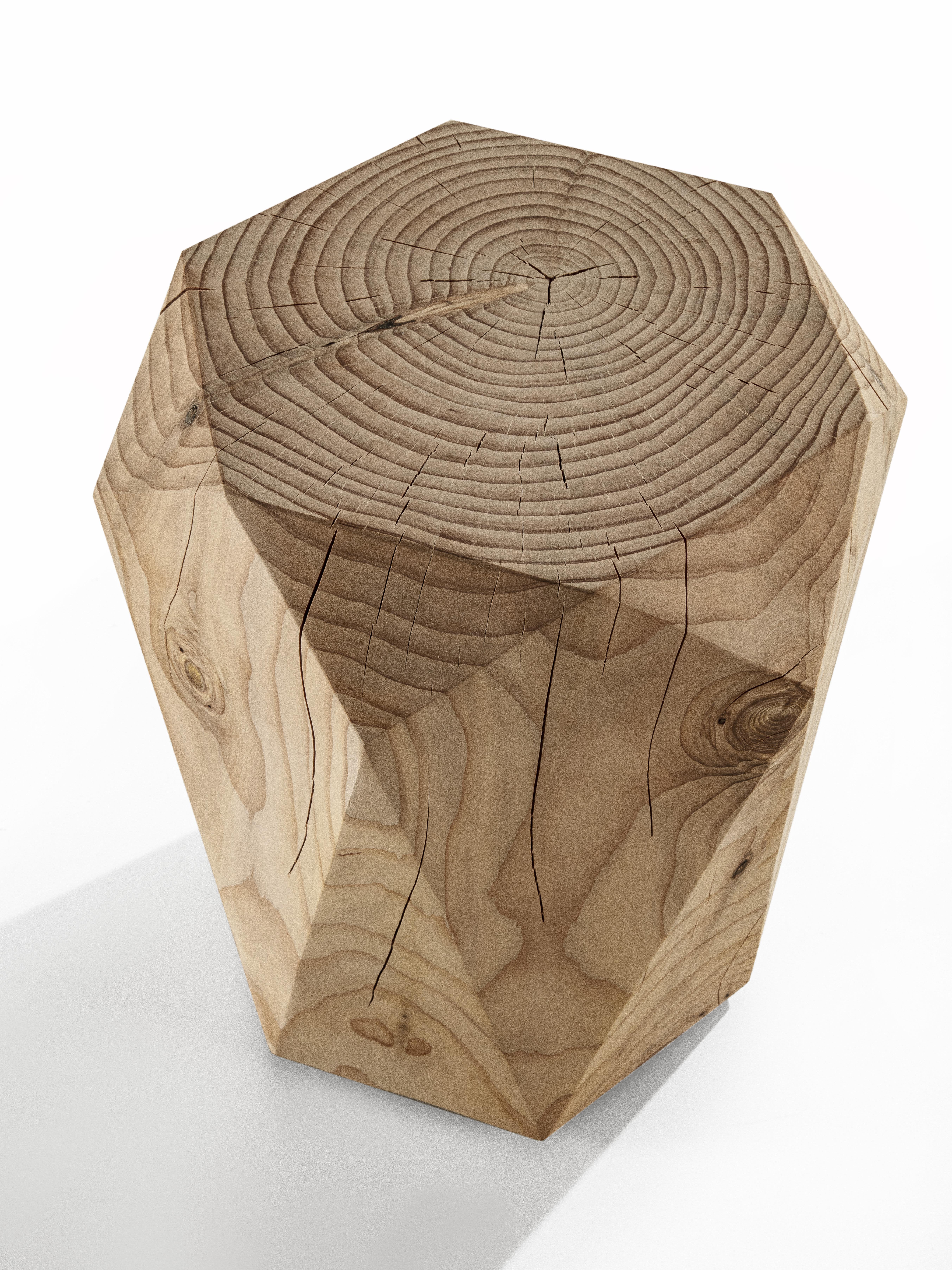 Stool made of a single block of scented cedar with hexagonal base, which develops with a symmetry of faceting that recalls the eternal elegance of precious stones.