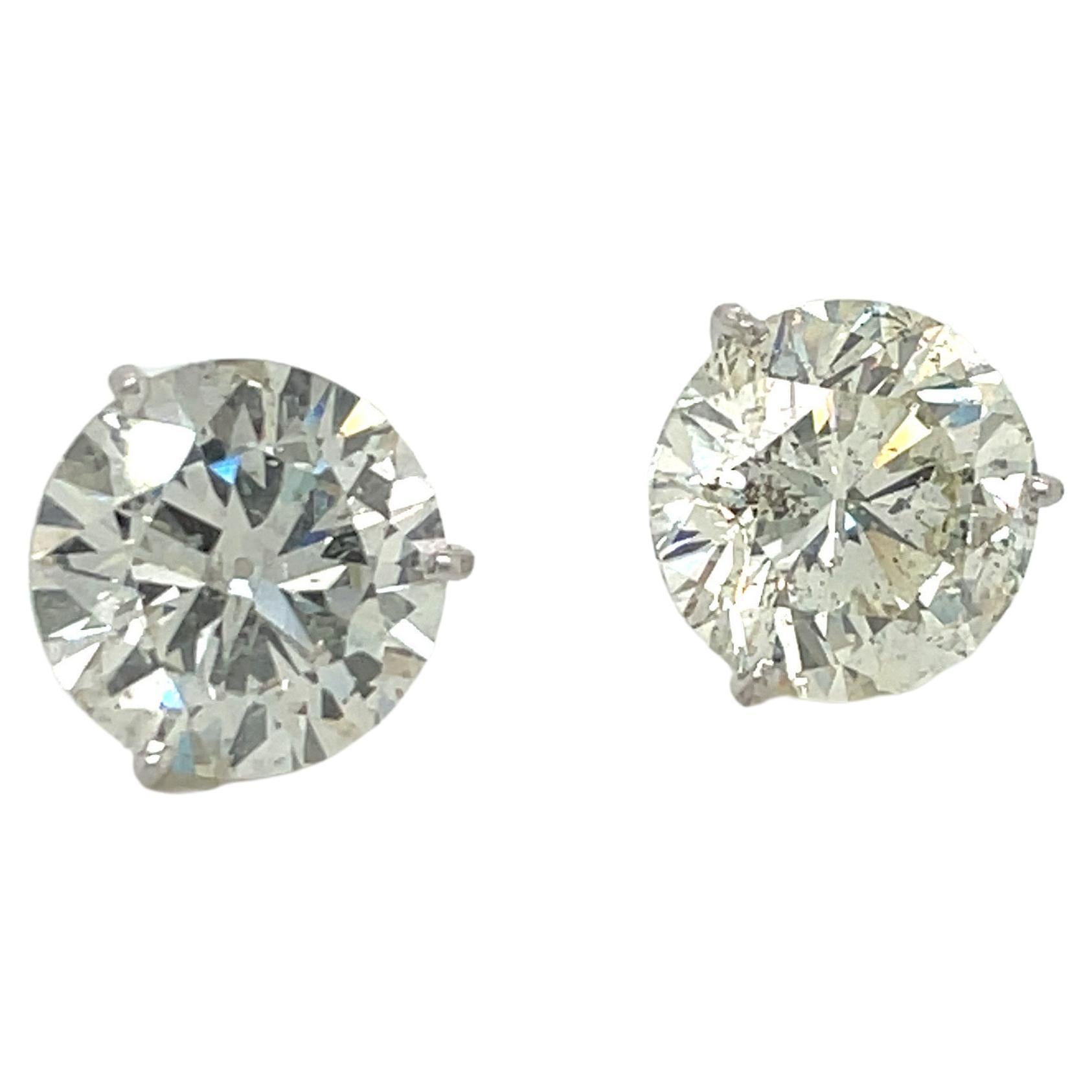 Diamond stud earrings weighing a total of 11.76 Carats in a 3 Prong Martini setting, crafted in Platinum. 
Color L
Clarity I1
Measures: 11-11.2 MM
Eye clean & lively.
Pictures show more of the inclusions. 
Video is more accurate to the naked eye. 