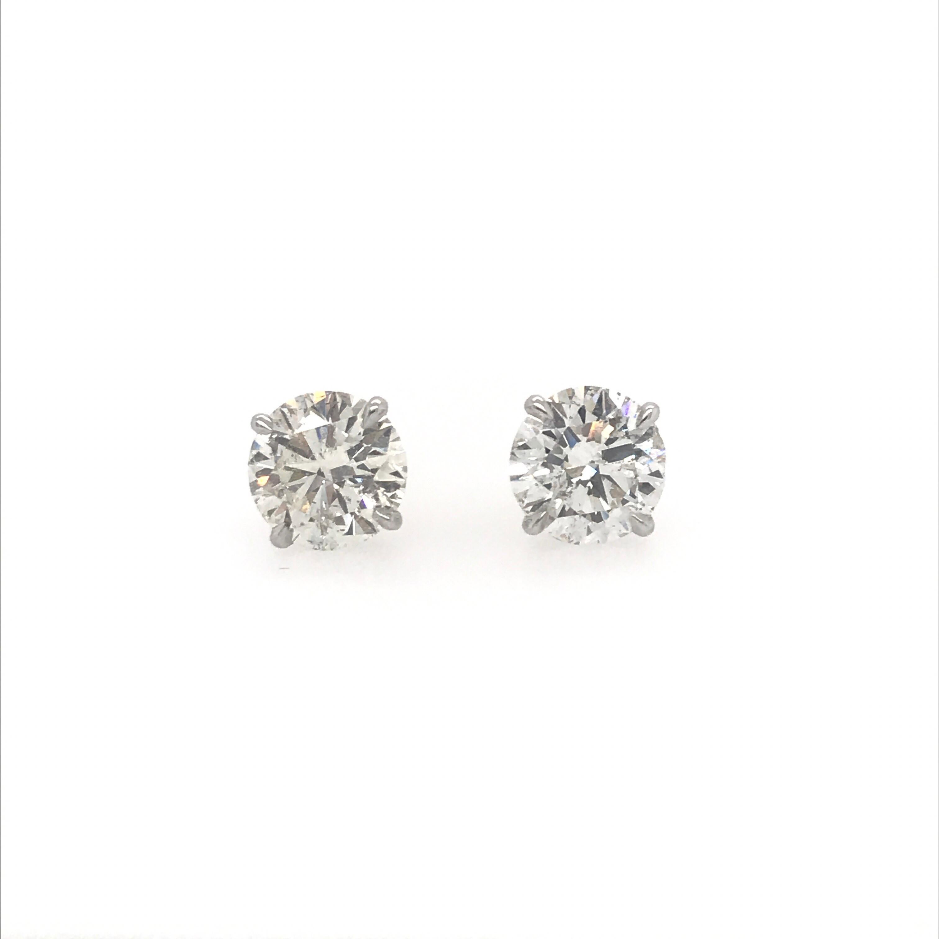 A pair of diamond stud earrings weighing 4.62 carats in 18k white gold four prong champagne setting. 
Color I-J
Clarity SI3-I1