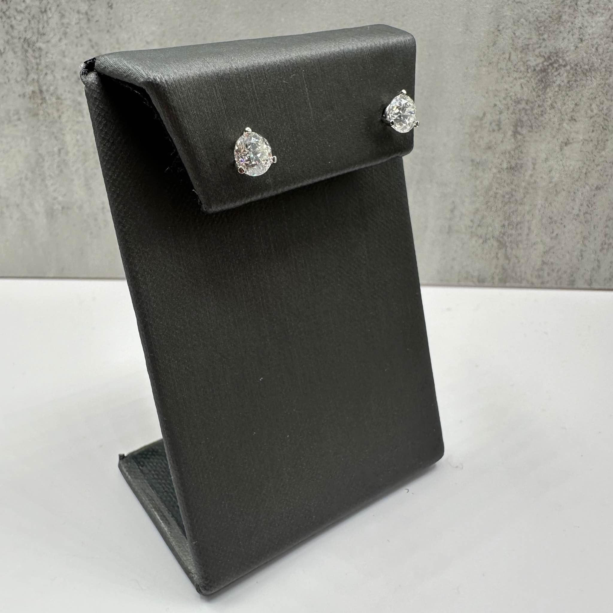 These stunning Natural Diamond Stud Earrings in 14kt white gold feature 2ctw of natural GH I1 round diamonds, each measuring over 6.2mm, offering brilliant sparkle in a timeless design. The diamonds are set in a 3-prong martini setting, enhancing