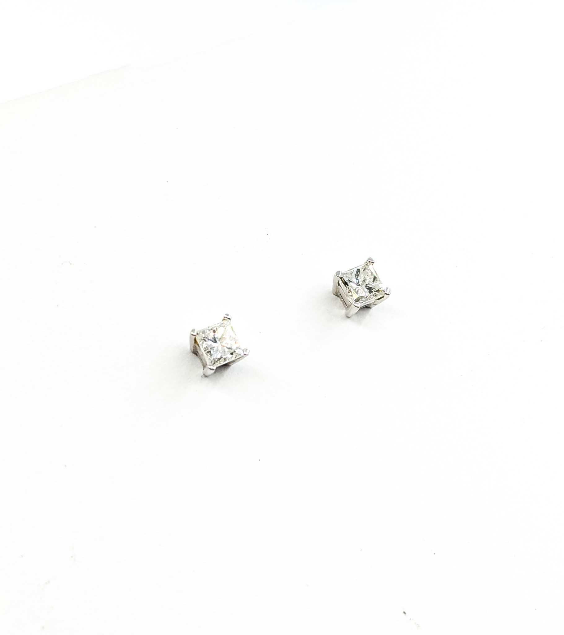 Boucles d'oreilles à vis en or blanc 14k avec clous d'oreilles en diamant

Ces boucles d'oreilles sont fabriquées en or blanc 14k et présentent un diamant serti sur la tranche, avec un clou à vis. Les diamants princesse totalisent 0,80ctw, presque