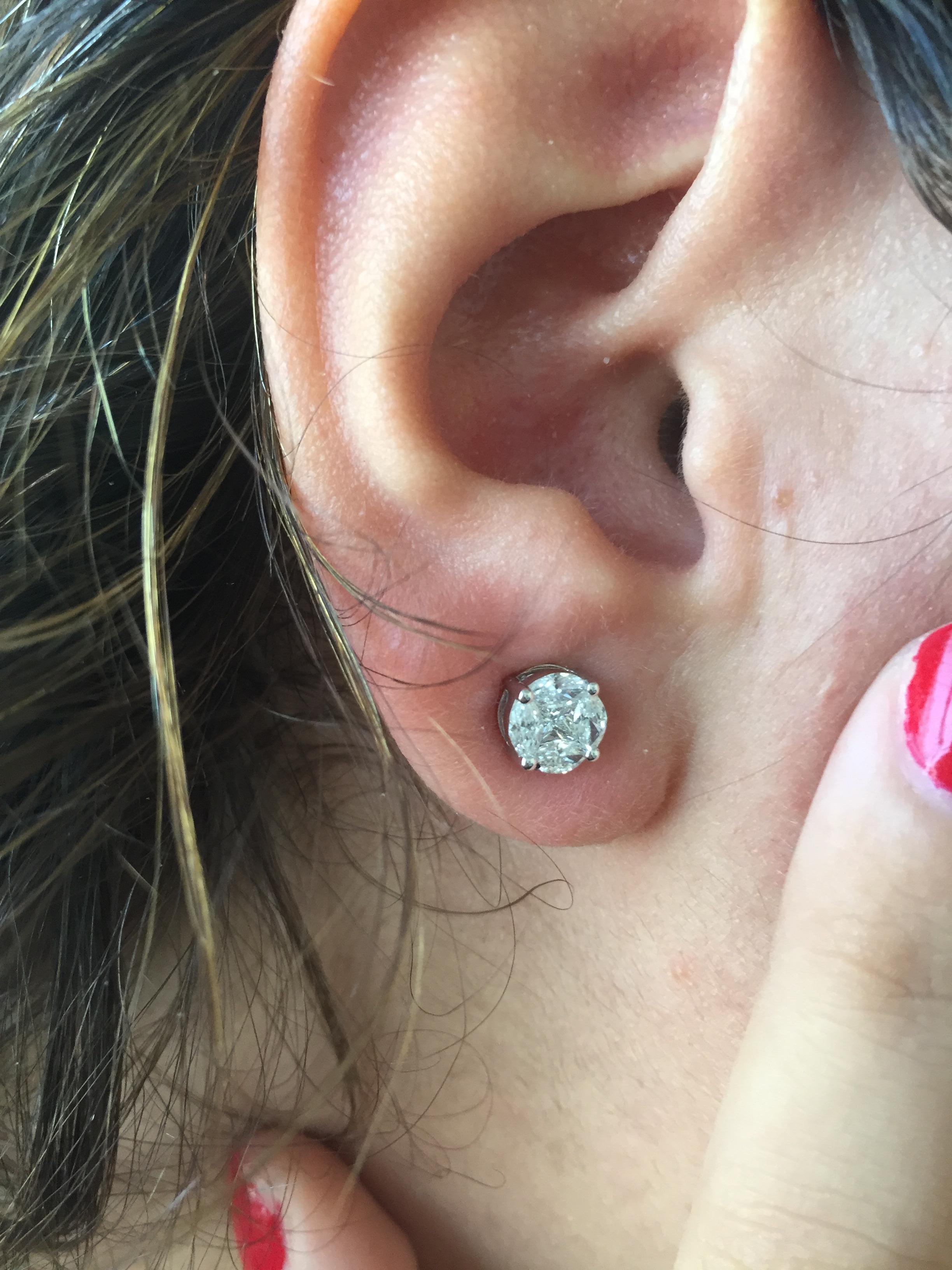 Ces clous sont faits d'une combinaison de pierres qui créent l'illusion d'une seule grosse pierre. Ces boucles d'oreilles ont un aspect de 2.00 Carats chacune. La couleur de la pierre est F, la clarté VS. Boucles d'oreilles en or blanc 18 carats.