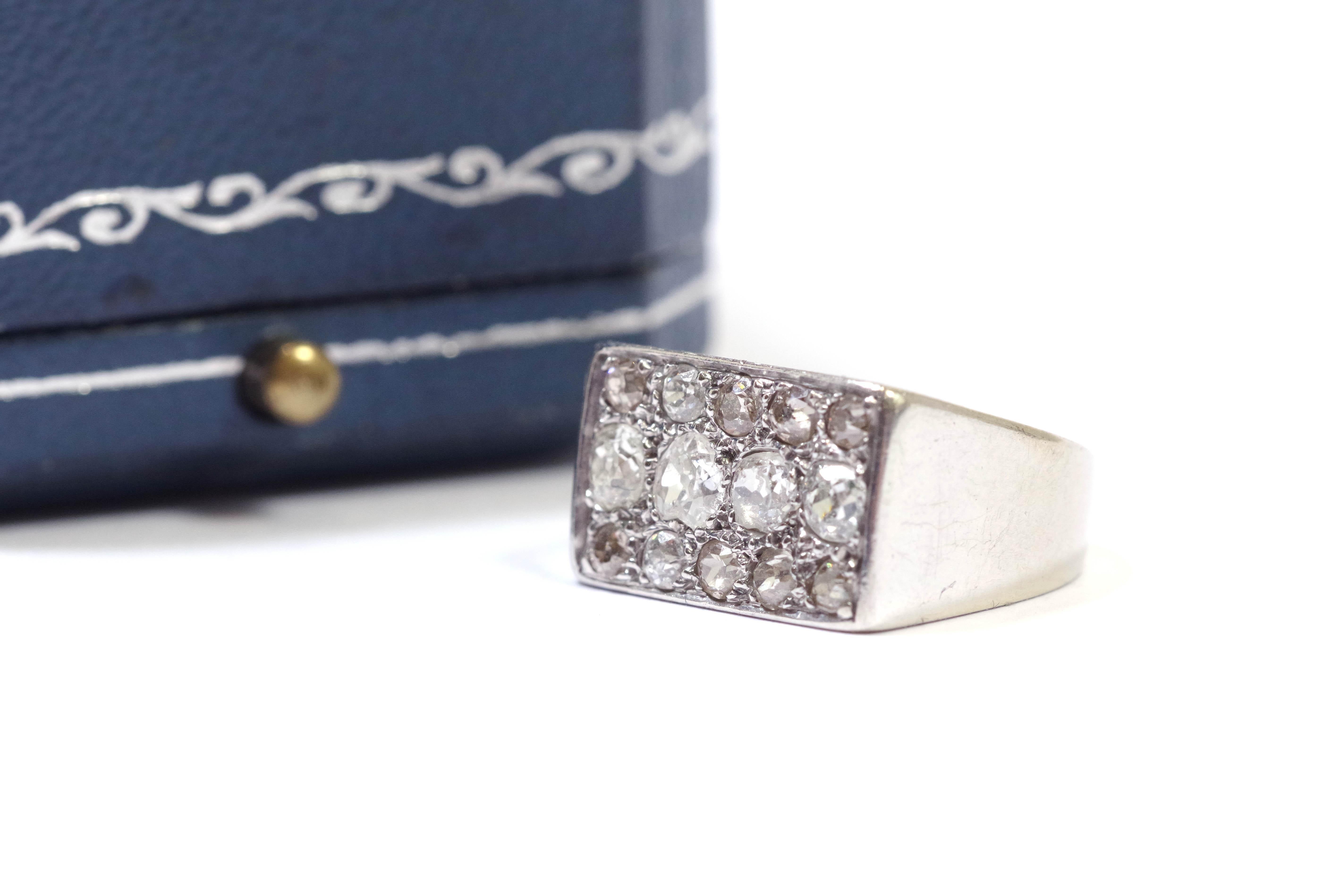Bague Art déco en or blanc 18 carats. La tête de l'anneau est rectangulaire, avec des lignes géométriques simples. Il est pavé de quatorze diamants de taille ancienne, dont quatre plus importants au centre. Bague de la période Art déco, vers