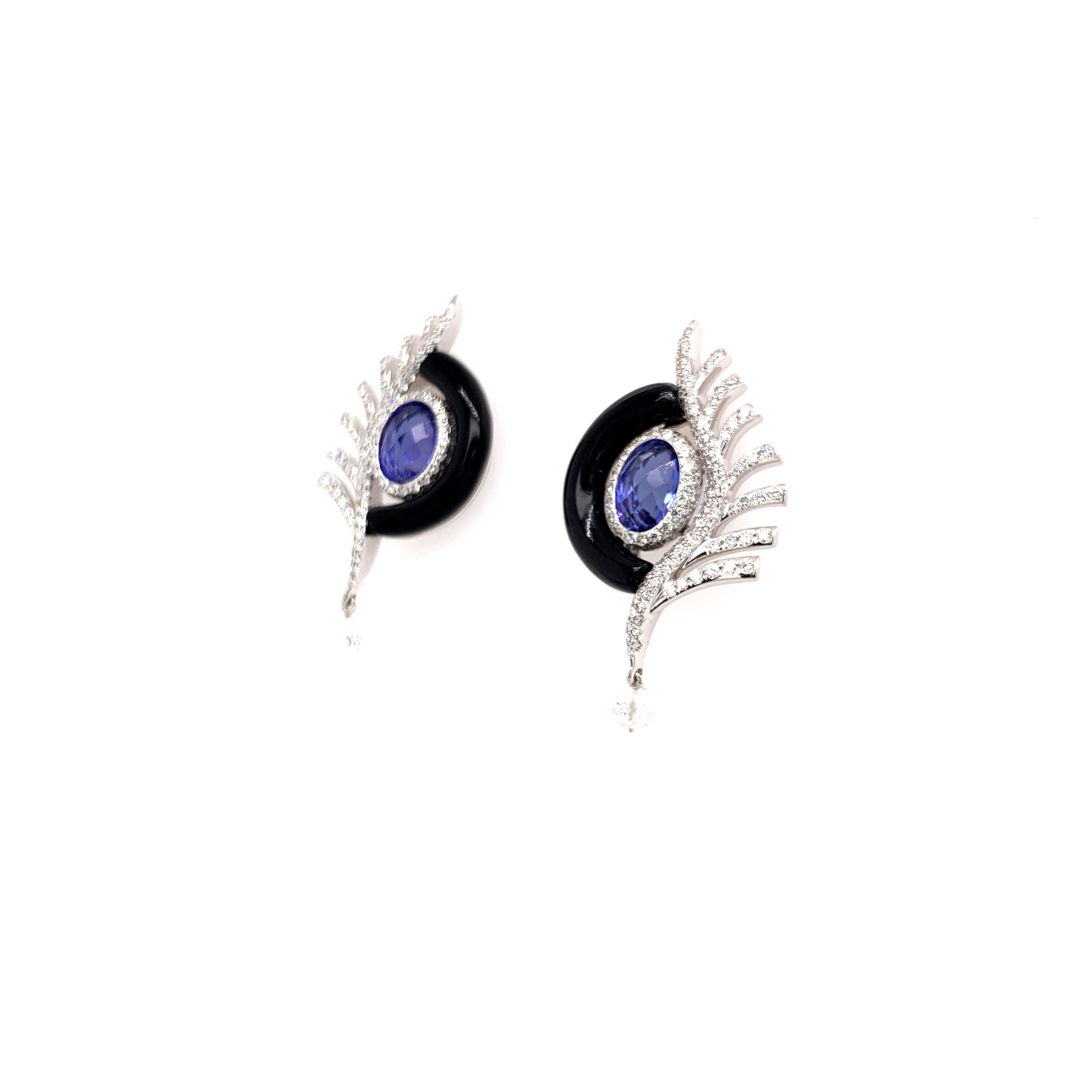 Stunning feather-inspired diamond earrings using hand-cut onyx and gorgeous tanzanite ovals in 18 karat white gold.

Round, brilliant-cut diamonds are pavé set along the feather and around the tanzanite oval. Diamond briolettes dangle at the bottom