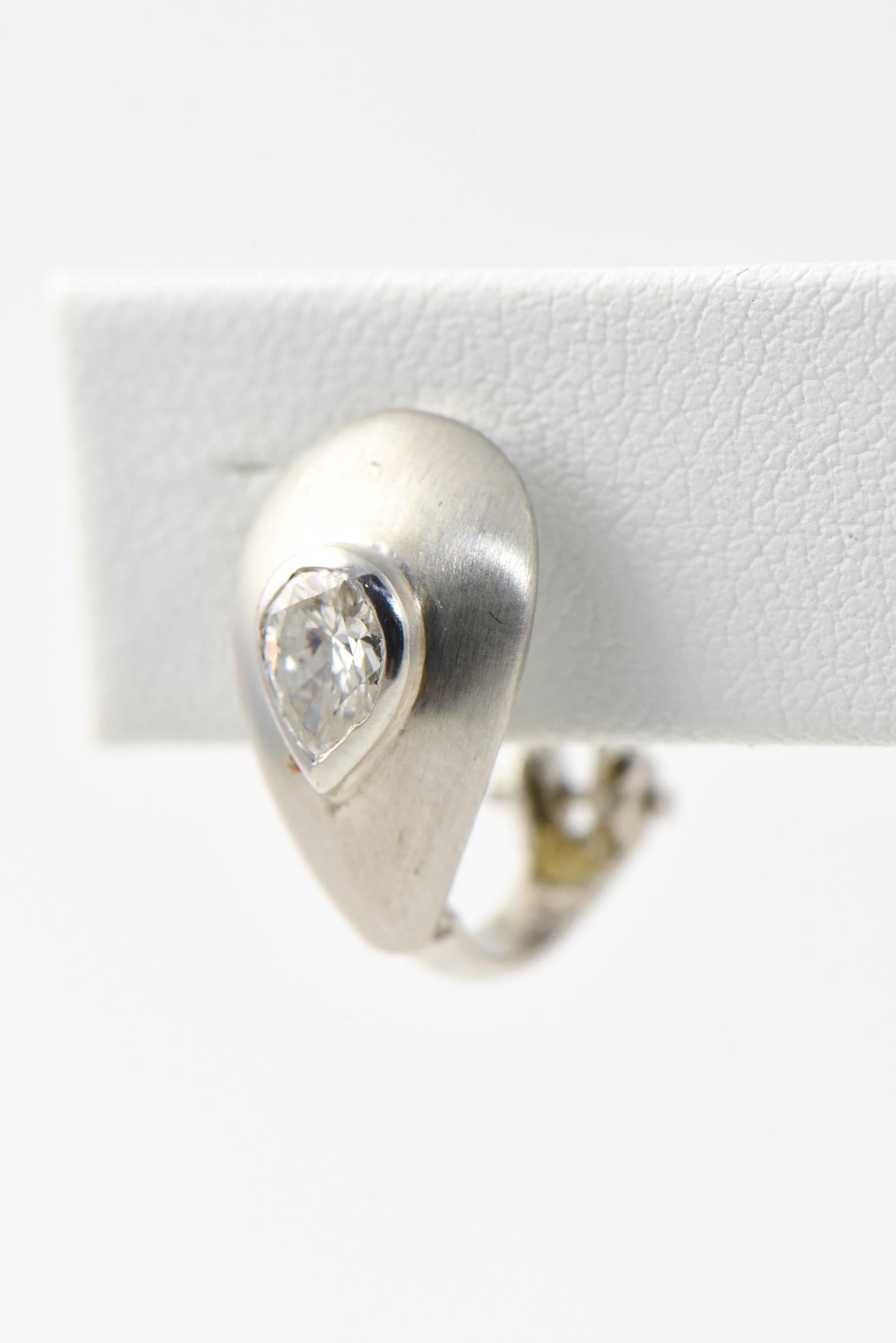 Brushed 14K white gold teardrop earrings with a bezel-set 0.35 carat pear-cut diamond in the center of each. Clip backs. Diamonds: G-H VS2-SI1. Some wear.