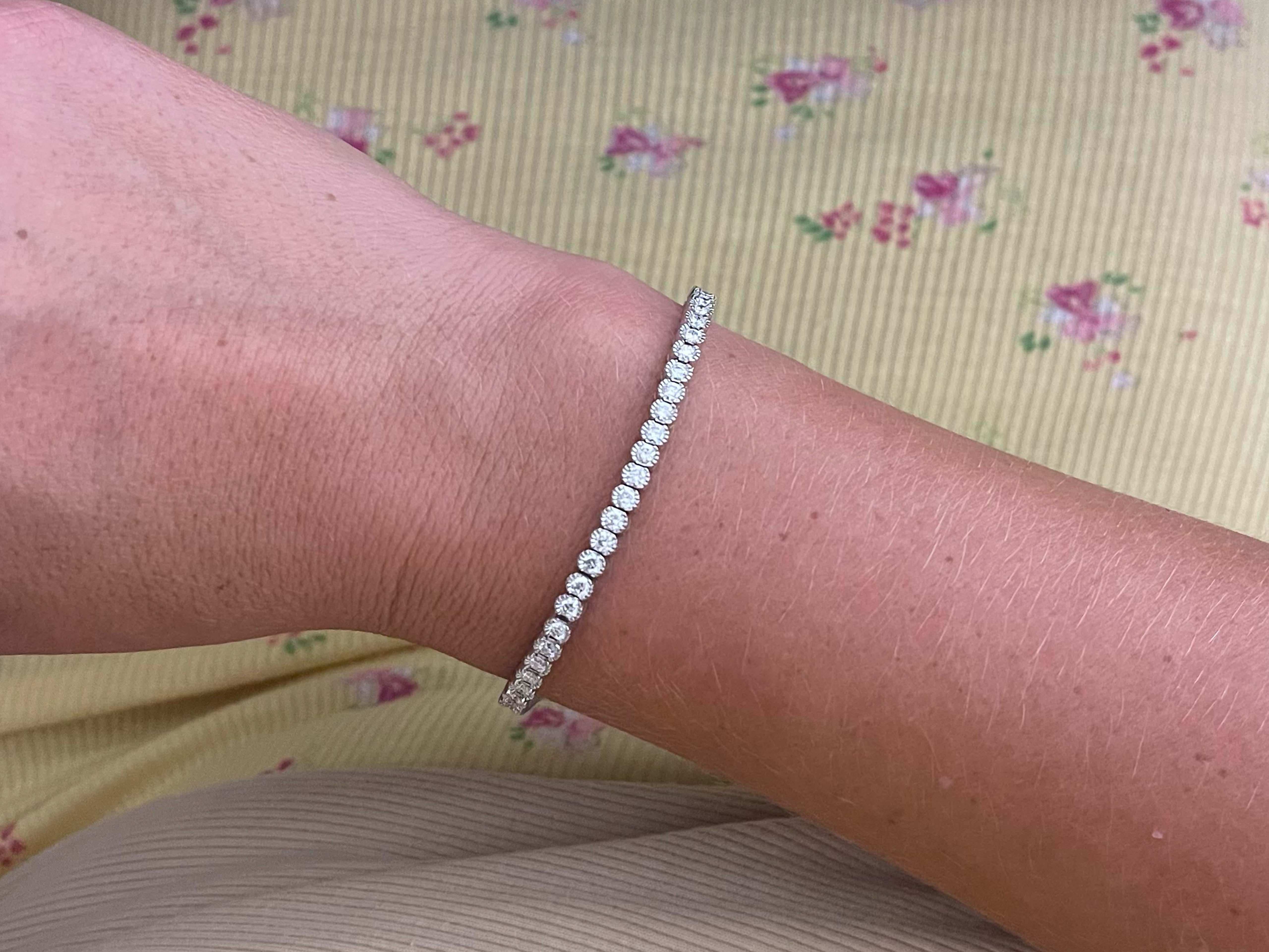 Gorgeous Diamond tennis bracelet in 18k white gold. This beautiful bracelet features 61 round brilliant cut diamonds, bezel set with mil-grain texture weighing a total of ~3.00 carats. The diamonds are G-H in color and VS2-SI1 in clarity. The