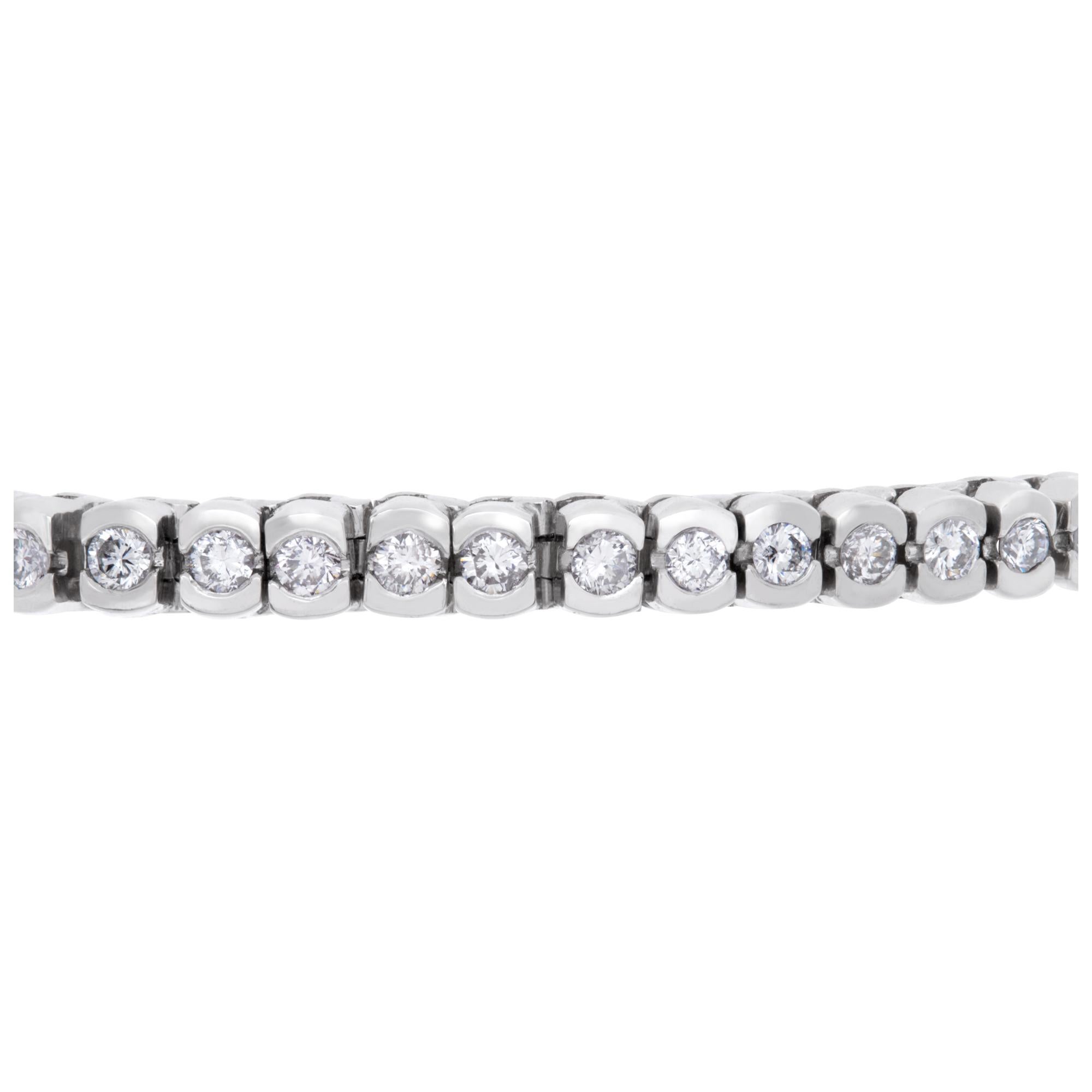 Pulsera de tenis de diamantes en platino con aproximadamente 6 quilates de diamantes redondos engastados en bisel (color G-H, pureza VS1-VS2). La pulsera tiene cierre de seguridad con cadena. Longitud 7,5'', anchura 4 mm.