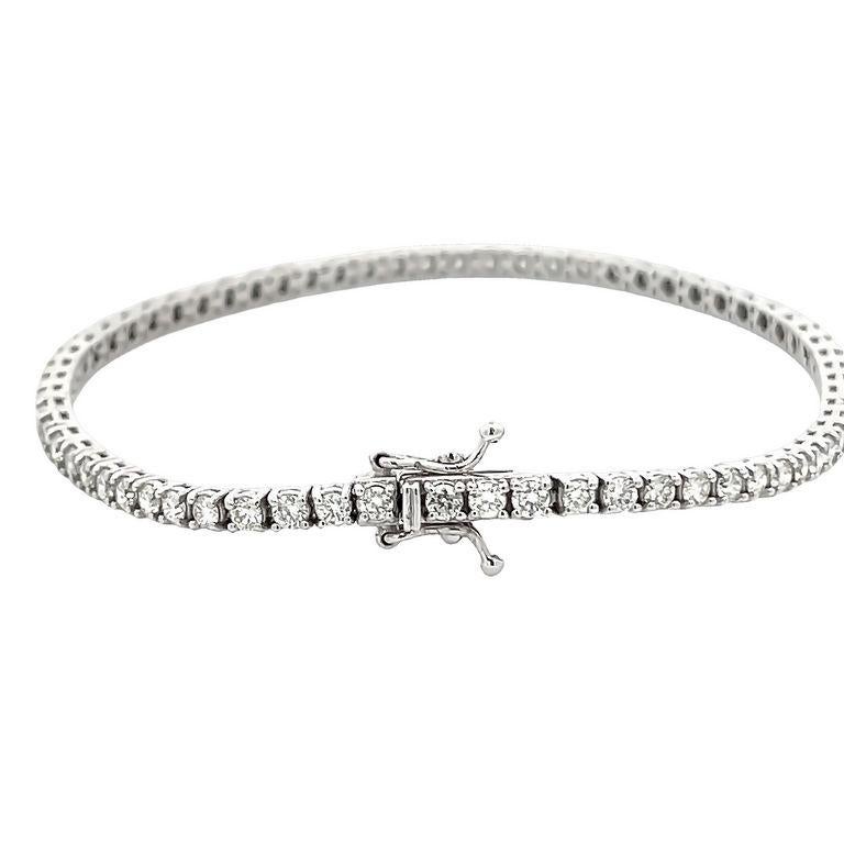 This classic tennis bracelet is a stylish choice for those looking to add a touch of elegance to their look. It is made from polished 14K white gold and boasts a bright luster that catches the eye. The bracelet features sixty - seven round white