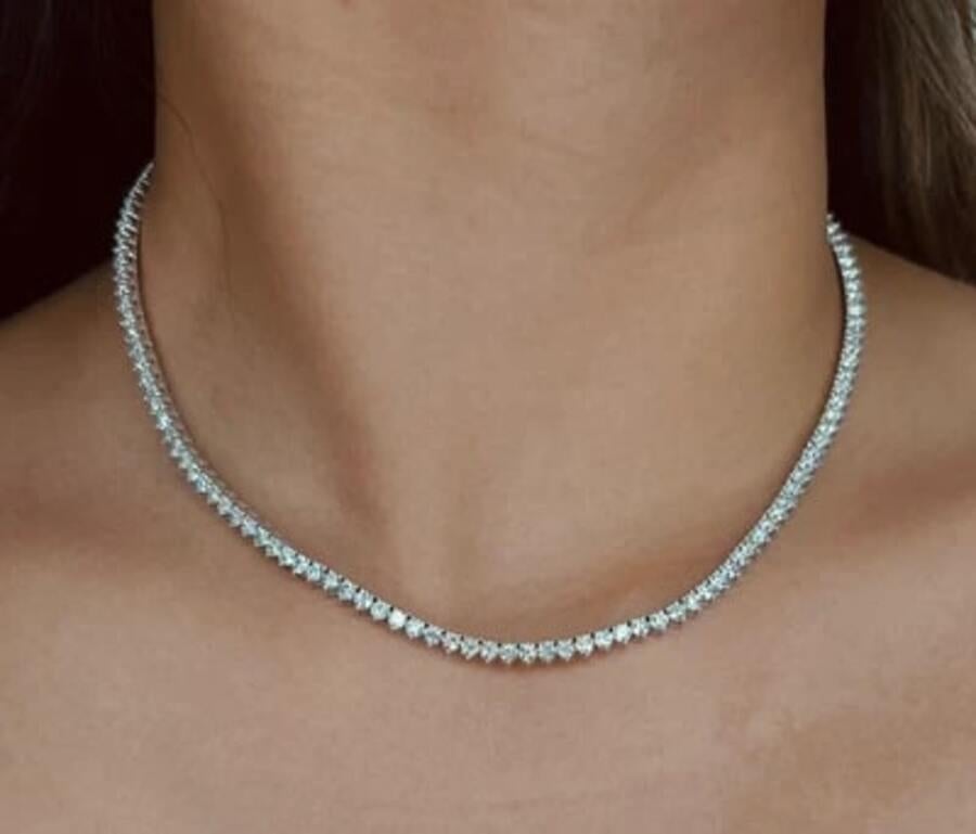 This elegant Three Prong Emerald Stone 14K Gold Tennis Necklace showcases a timeless design with a luxurious 14K gold setting. Available in yellow, rose, or white gold, it features dazzling diamonds that perfectly complement the rich hue of the