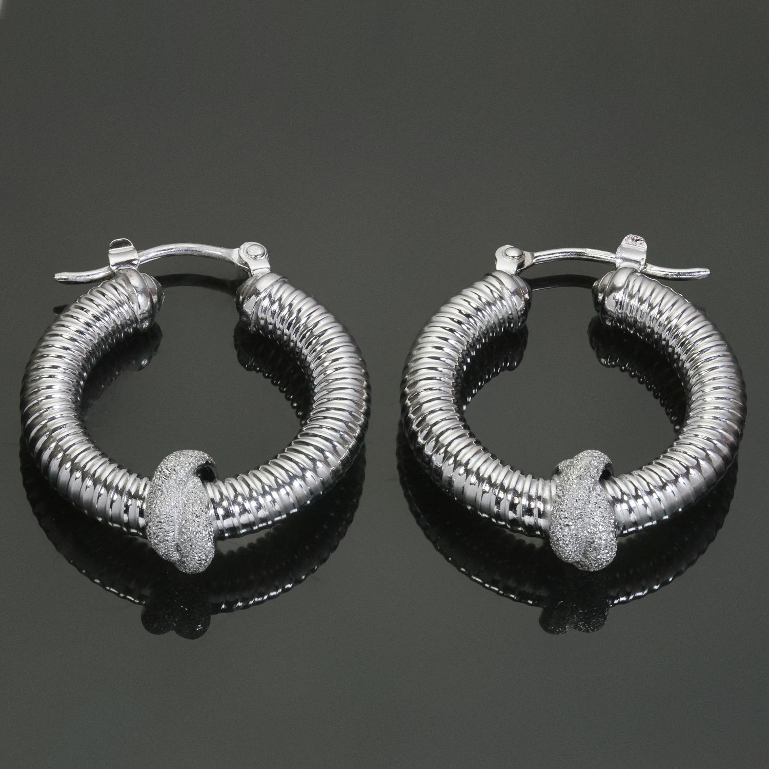 These classic estate ridged hoop earrings are crafted in 14k white gold and feature a textured gold accent meant to look like a pave-setting of diamonds. Made in United States circa 1980s. Made in United States circa 1980s. Measurements: 0.15