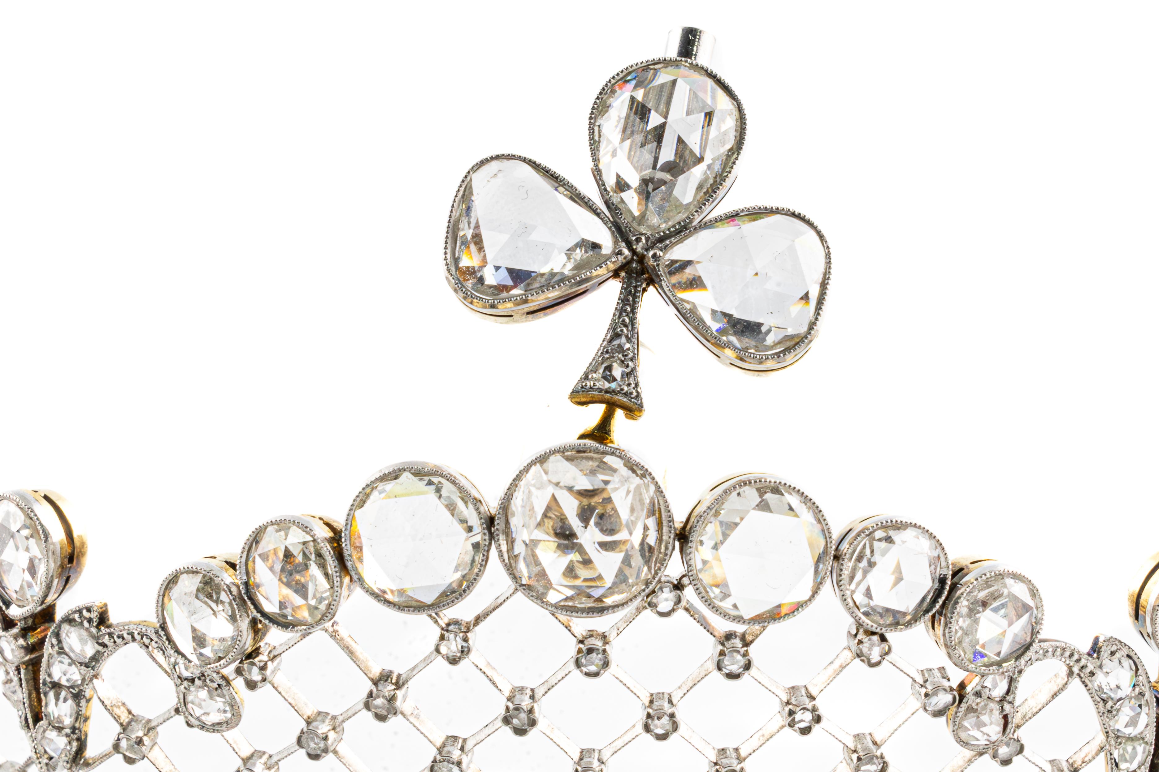 esta impresionante tiara es una visión de la elegancia y el refinamiento. Realizado en oro blanco de 18 quilates y platino, presenta un intrincado diseño en forma de celosía adornado con brillantes diamantes talla rosa y talla vieja europea. El
