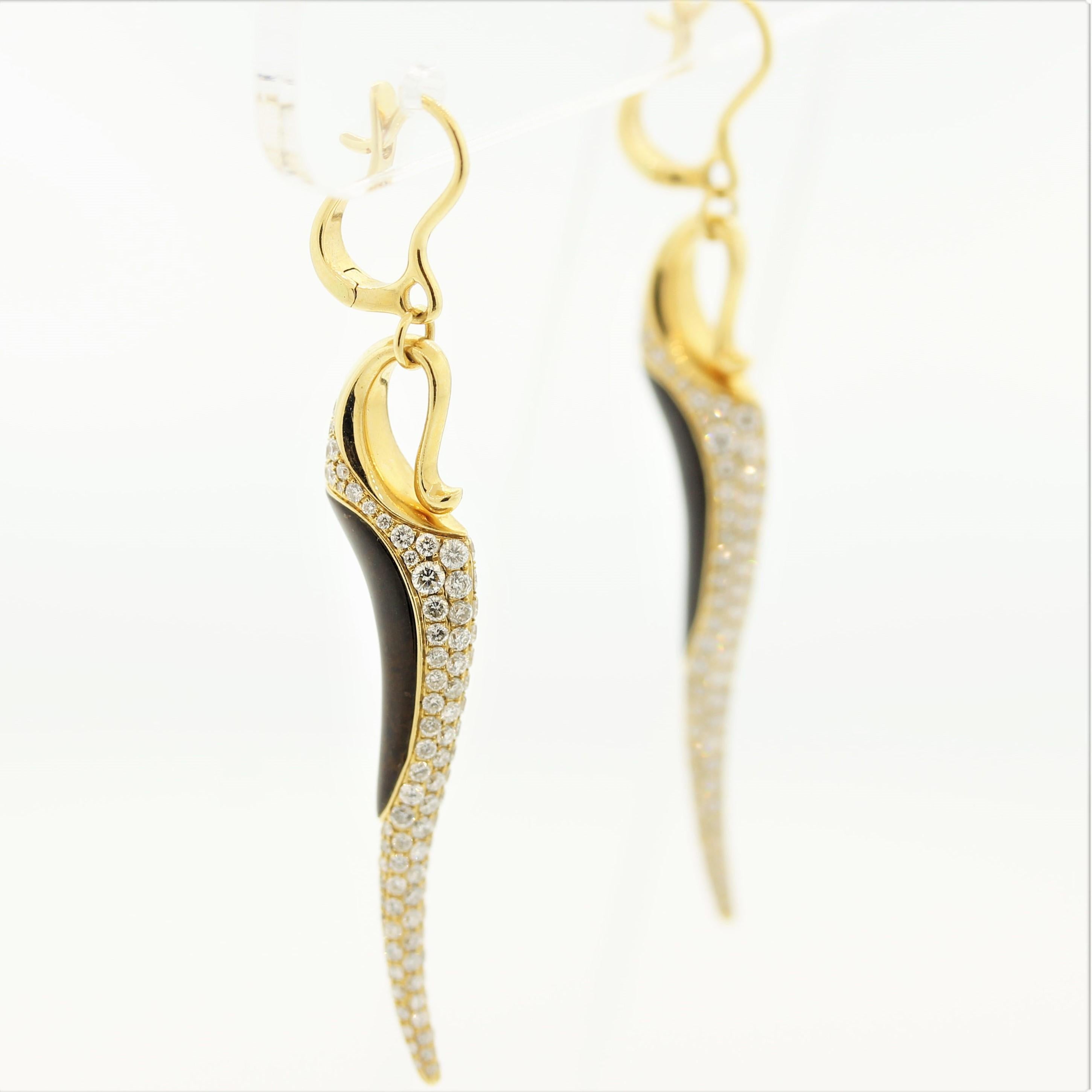 A sleek and sexy pair of earrings! They feature 2.75 carats of fine round brilliant-cut diamonds which are pave-set across the earrings. Accenting the diamonds are 7.62 carat of tiger’s eye which appears to change colors as the earrings are moved.