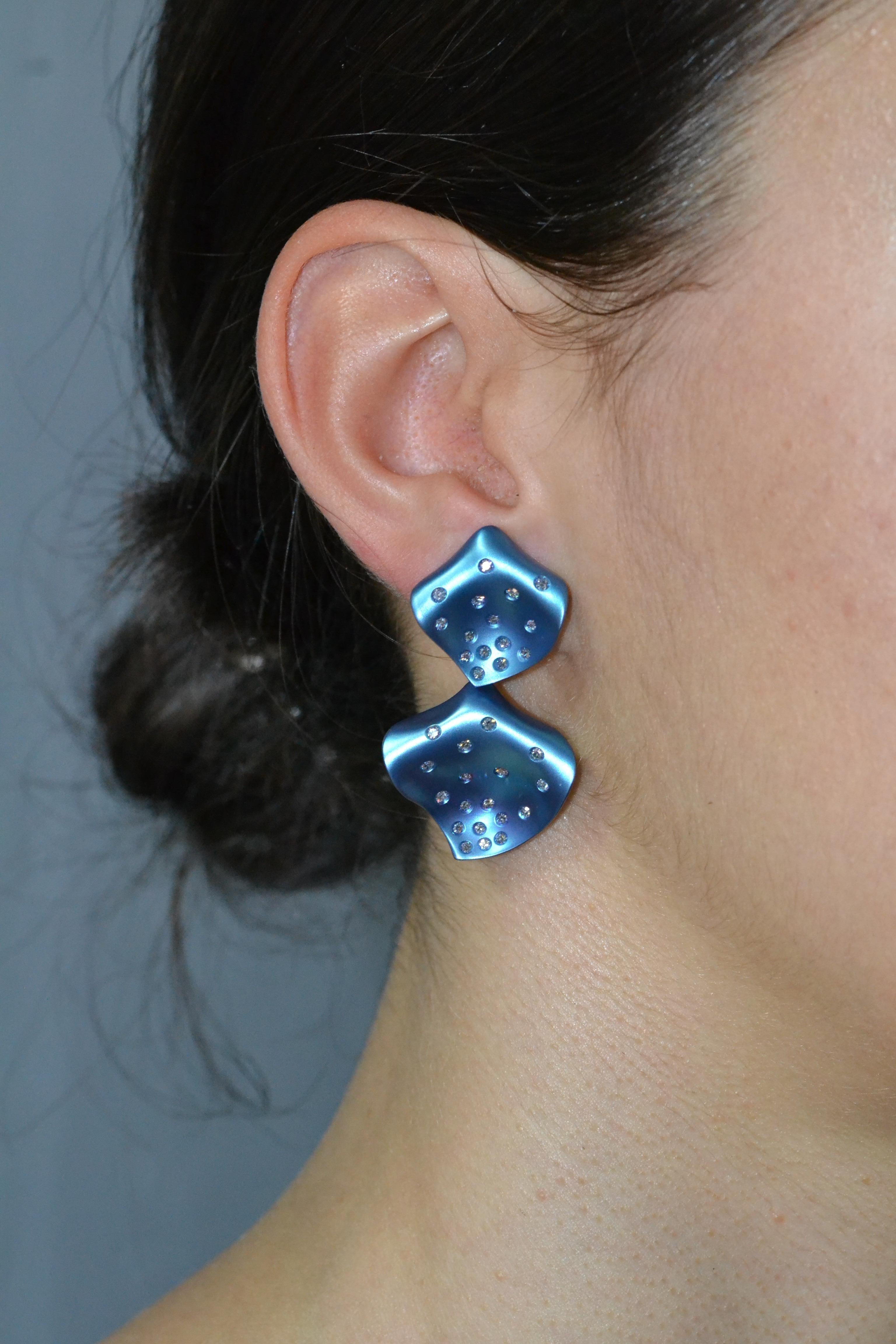 Handcarved earrings in titanium, oxidized petrol blue titanium (color in titanium is stable).
The lightness of titanium make them very comfortable and enjoyable.
Featuring fittings and butterflies.

18 KT white gold grams 1.16
n. 67 diamond total