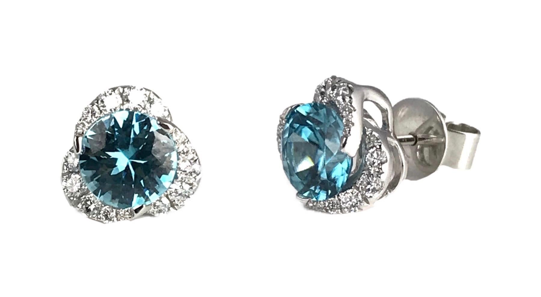(DiamondTown) These earrings have 2.66 carats aqua blue zircon inside a graduated swirl of white diamonds. The total diamond weight is 0.48 carats.

Item details:
Center: 2.66 carats blue zircon, round
Diamonds: 0.48 carats
Set in 14k white