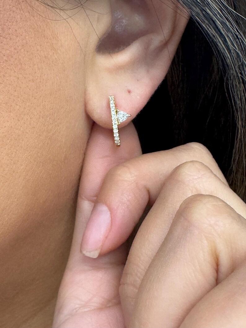 Boucles d'oreilles en or jaune 14 carats avec un diamant Trilliant sur le côté et des diamants ronds pesant 0,42 carats.

Plus de cerceaux disponibles
Message pour photos et détails
Recherche Harbor Diamonds