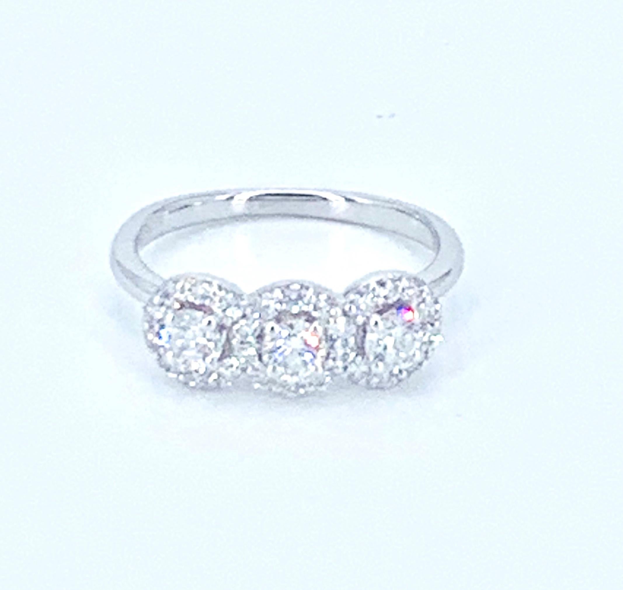 This beautifully bright 0.50 carat diamond Trilogy ring, illuminates the finger with the halo style design to each of the 3 large diamonds. 

Set in 18Kt White Gold, it is a timelessly precious and gorgeous ring one can wear on a daily basis or at