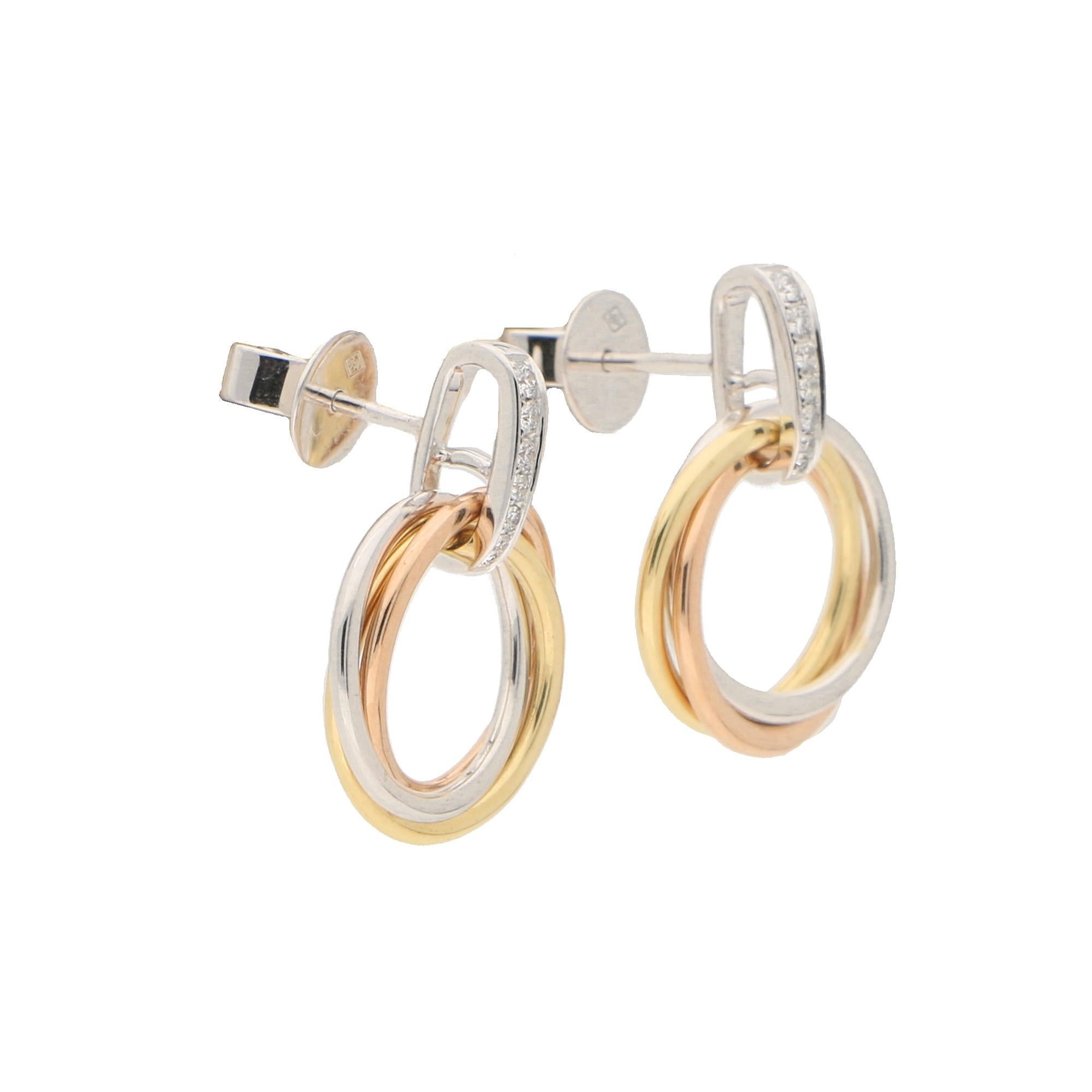 A lovely little pair of modern style trinity drop earrings set in 18k yellow, rose and white gold. 

The earrings are composed of three intertwined tricoloured gold hoops. These hoops are locked into their trinity style by a pavé set white gold