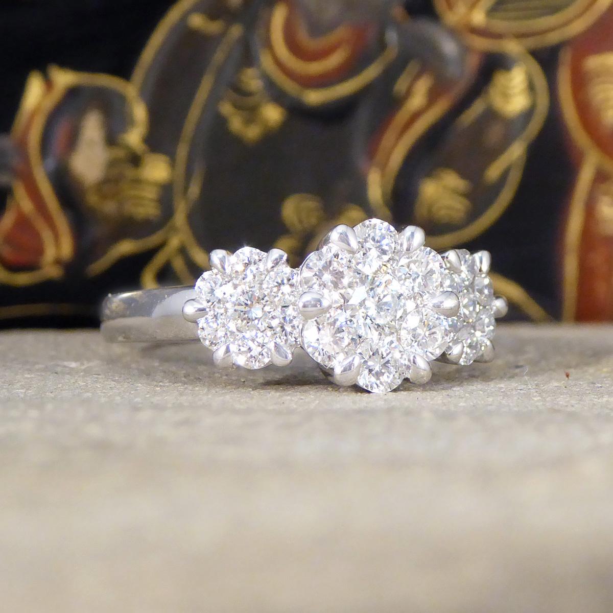 A gorgeous Diamond triple Daisy cluster ring—a pinnacle of sophistication and brilliance. The Diamonds are in a cluster to enhance sparkle and designed to created the illusion of a larger single stone creating the three stone arrangement in a