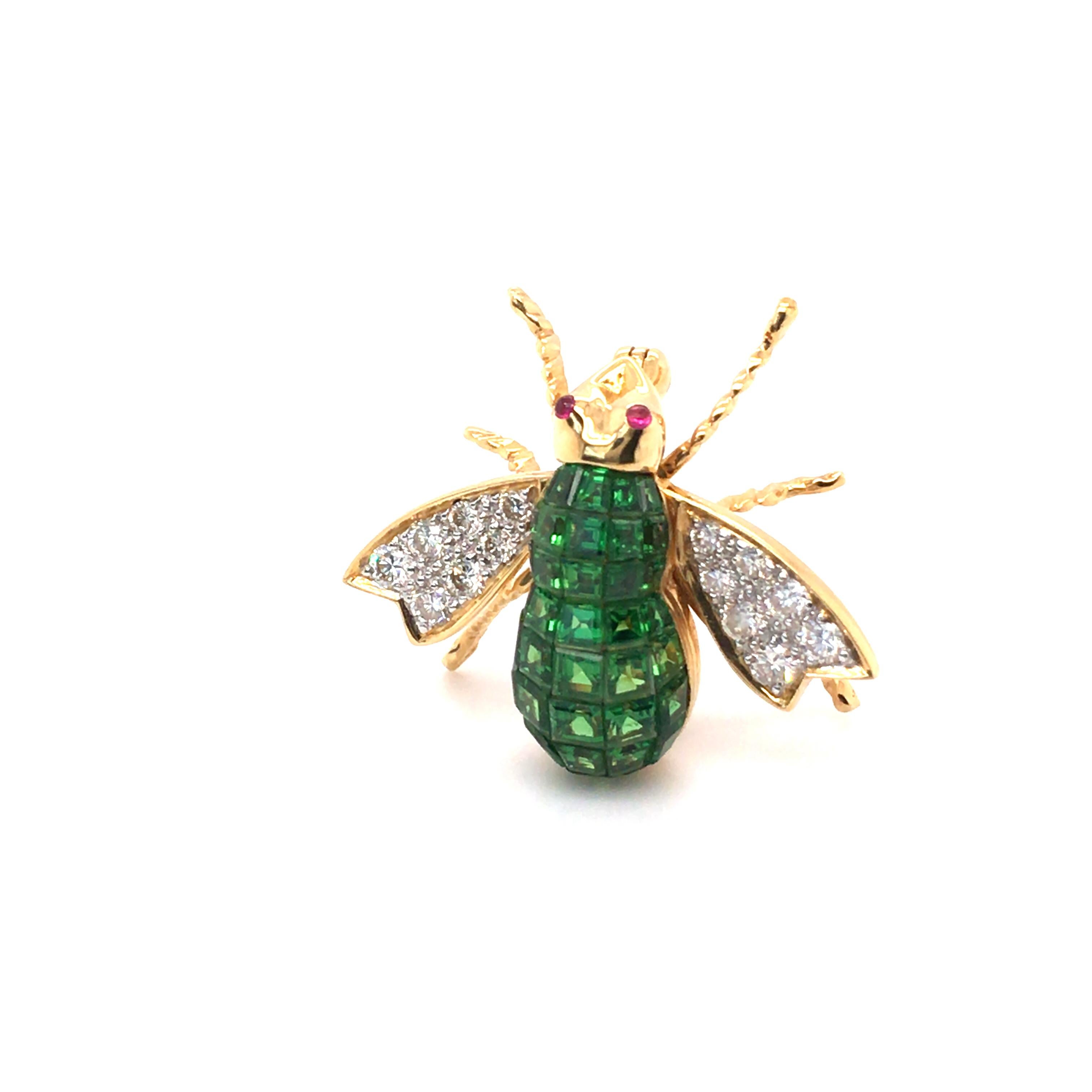 This charming insect brooch from the Haruni Vaults is handmade in 18k yellow gold with vibrant tsavorite garnets forming the body, pave-set sparkling diamonds in the wings, and round ruby cabochon eyes.