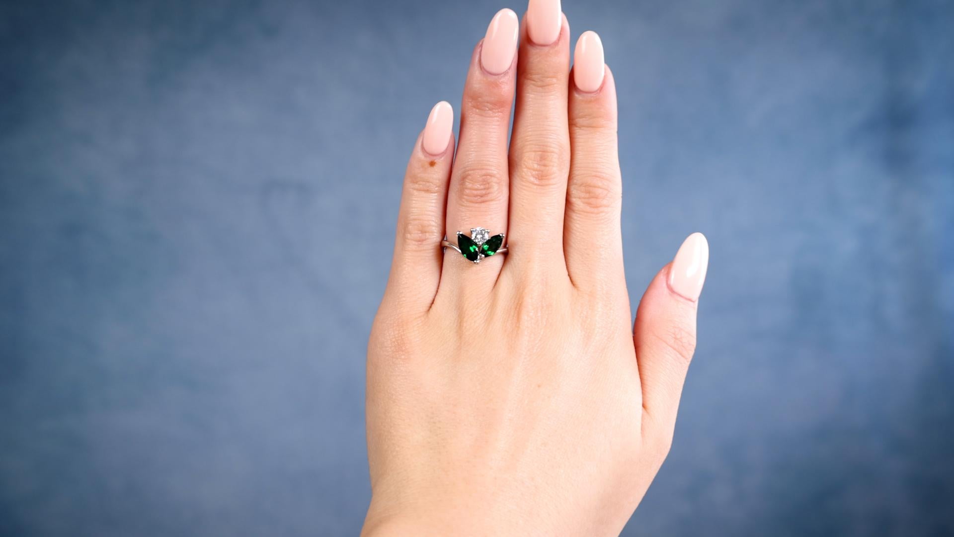 One Diamond Tsavorite Garnet Platinum Ring. Featuring one round brilliant cut diamond weighing 0.314 carat, graded G color, SI1 clarity. Accented by two marquise cut tsavorite garnets with a total weight of 1.32 carats. Crafted in platinum with