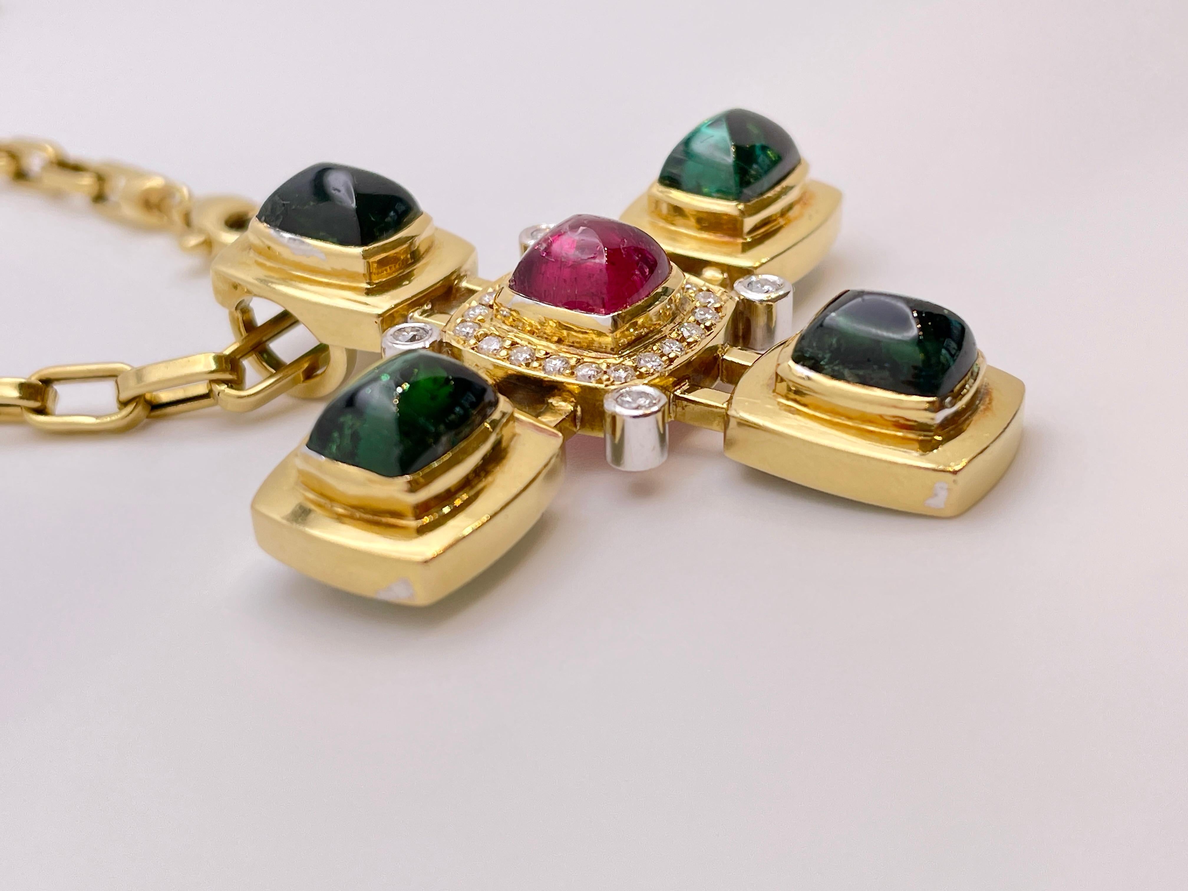 An original 18K yellow gold diamond turmaline cross pendant. Mounted with four large rectangular cabochon cut natural green turmalines stones, and centered with one rectangular cabochon cut pink turmaline. The green stones weigh approximately 5 CT