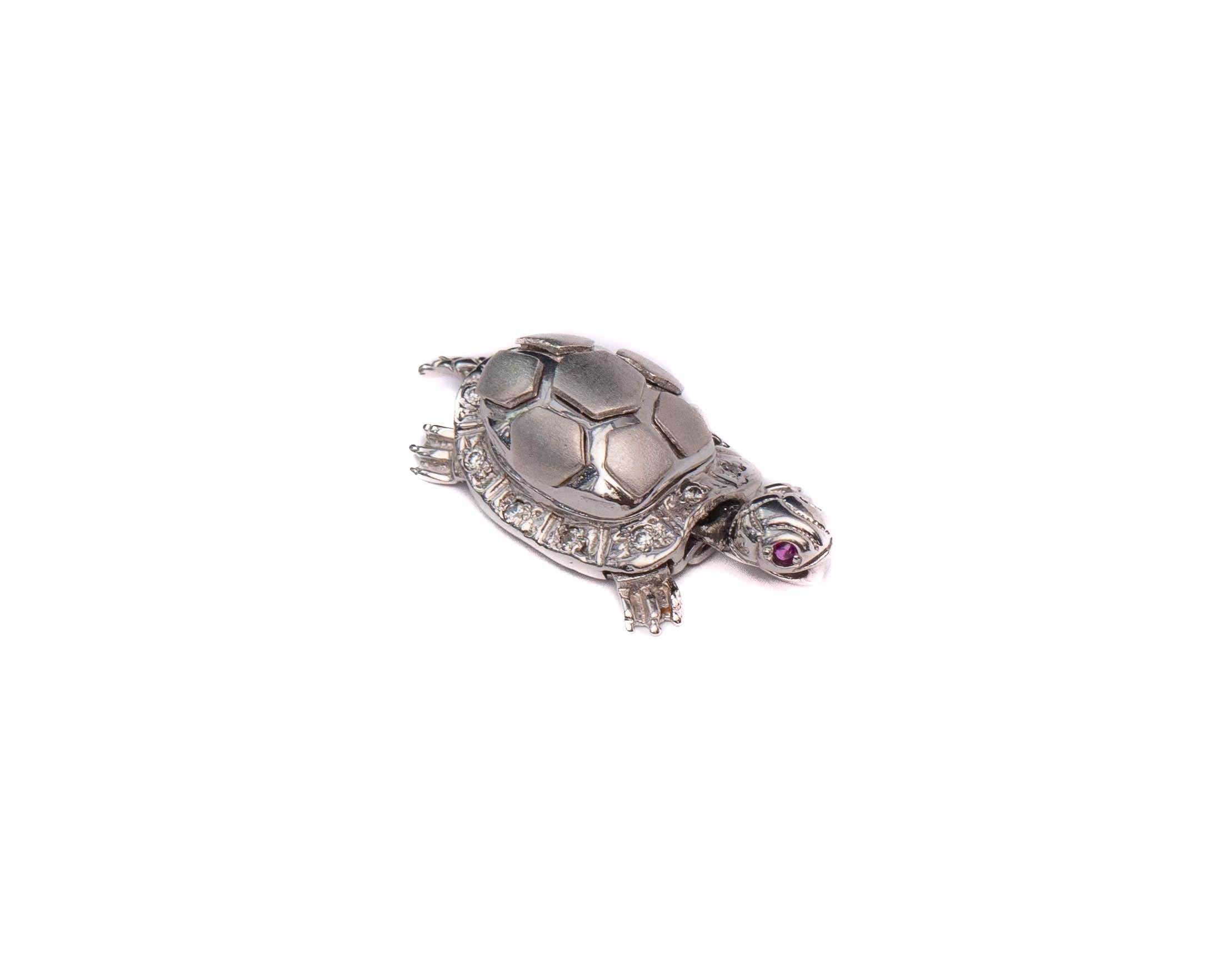 Pendant Details:
Metal type: 18 Karat White Gold
Weight: 6.06 grams
Measures: 1 inch length 

Features small diamond accents outlining the turtle shell
Features ruby accents on the eyes
Head and tail of the turtle articulate nicely 
The pendant is