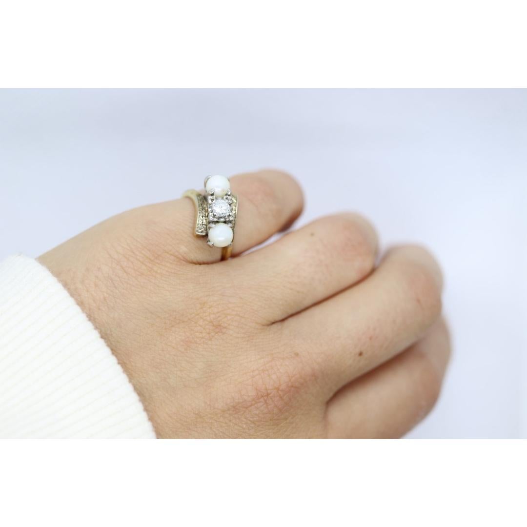 Vintage By aus den 1950er Jahren
Größe: 4 1/2 US
MATERIALIEN: Stein
Edelstein: Perle
Edelsteinfarbe: Farblos
Bandfarbe: Silber

Stil: Art deco

Zwillingsperle und zentraler Diamant Bypass-Ring. Graviertes Kirschblüten-Design auf beiden Seiten des