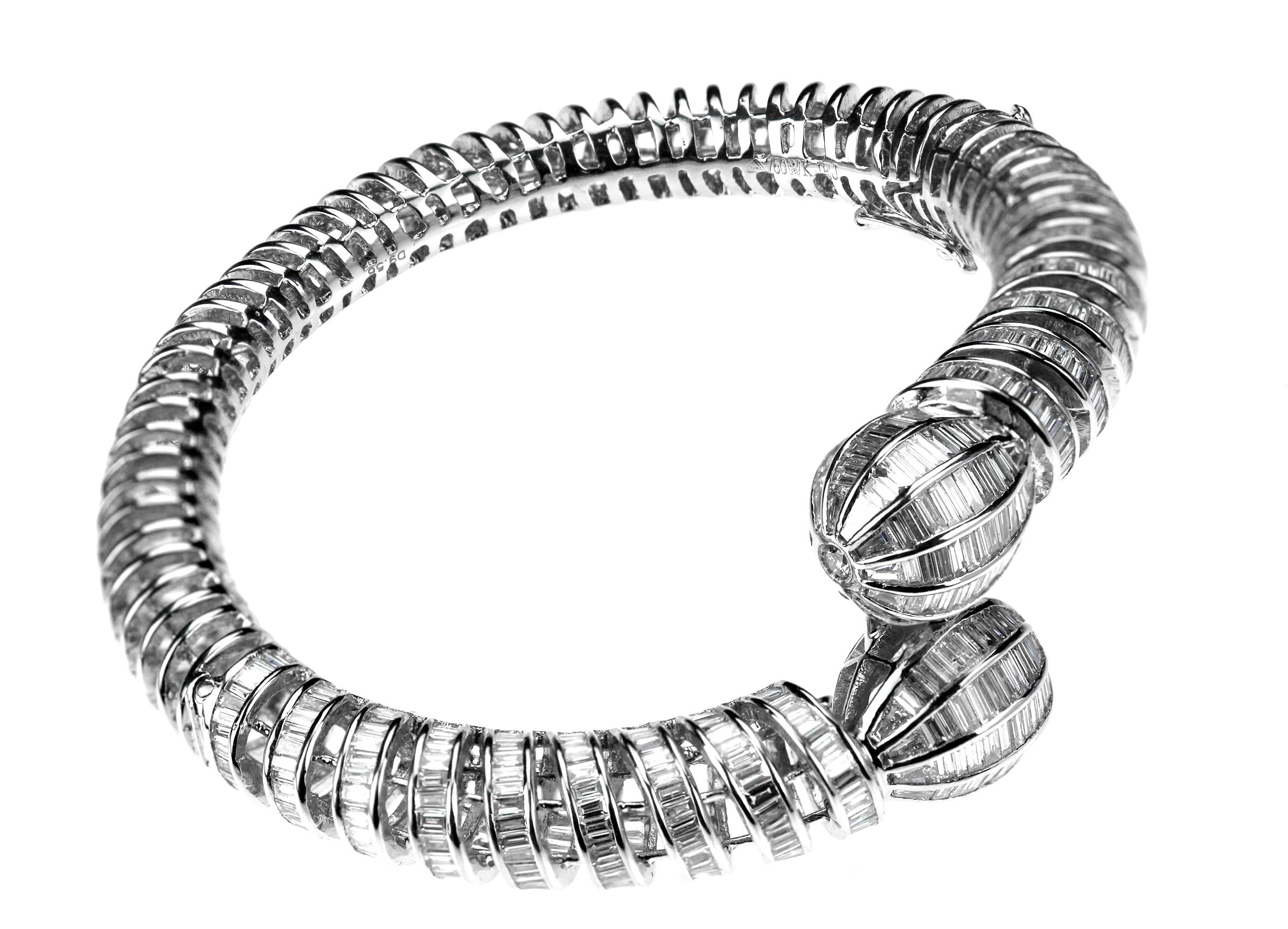 A dazzling diamond bangle set with baguette-cut diamonds and round brilliant cut diamonds. The twisted spring design gradually opening into two connected diamond-set knops, set with graduating baguette-cut diamonds to circular-cut diamond points.