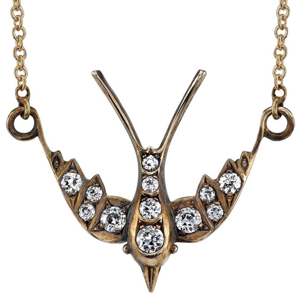 Approximately 0.30ctw G-H/VS old European cut diamonds set in a handcrafted 18k yellow and white gold Swallow necklace. Necklace is on a 16