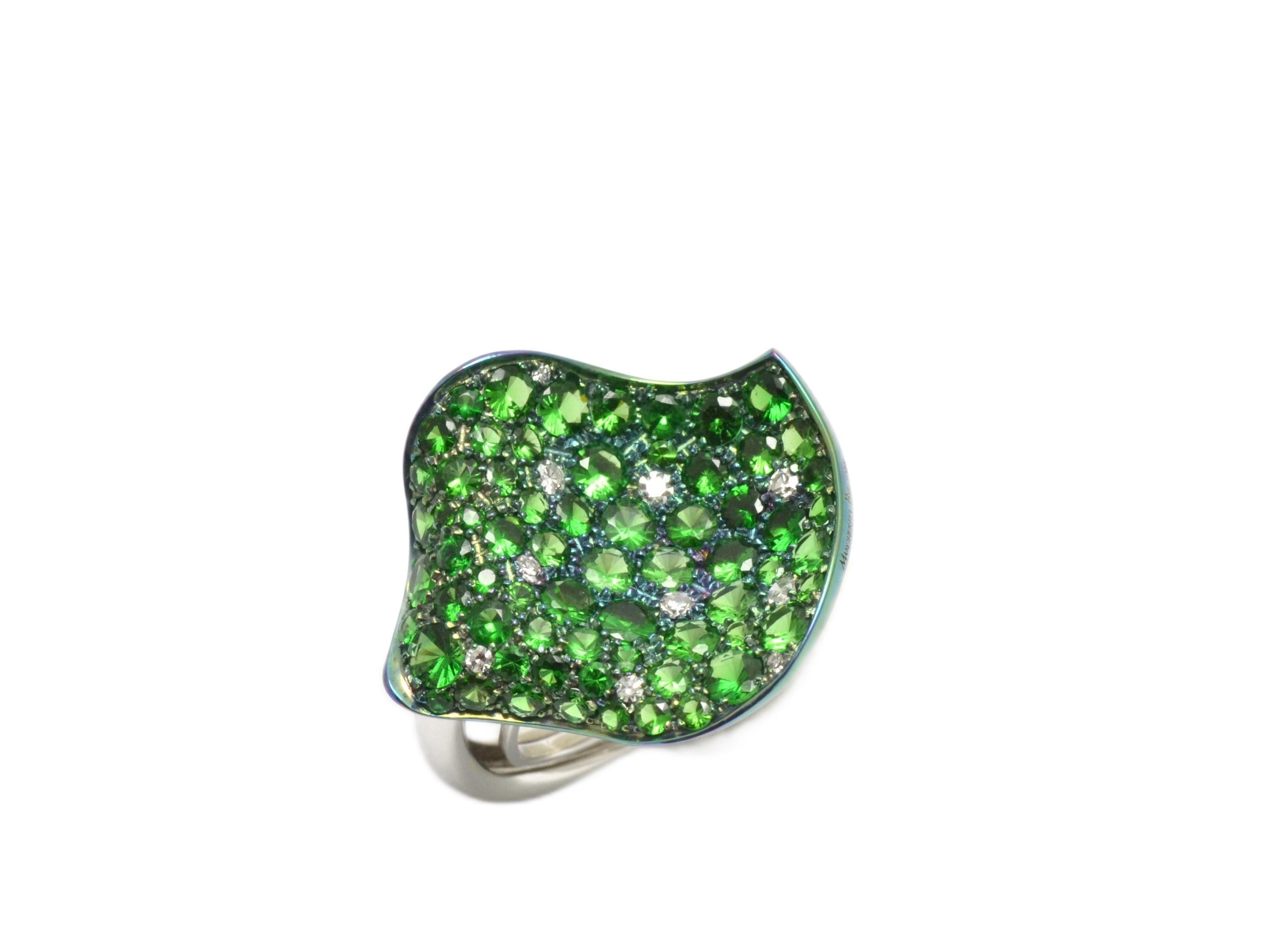 Handmade and hand shaped as a rose petal, the titanium ring is fully pavé set in tsavorite garnets, in different sizes, plus 10 round diamonds. Oxidated in green color (color in titanium is resistant), the ring features shanks in white gold.
Very