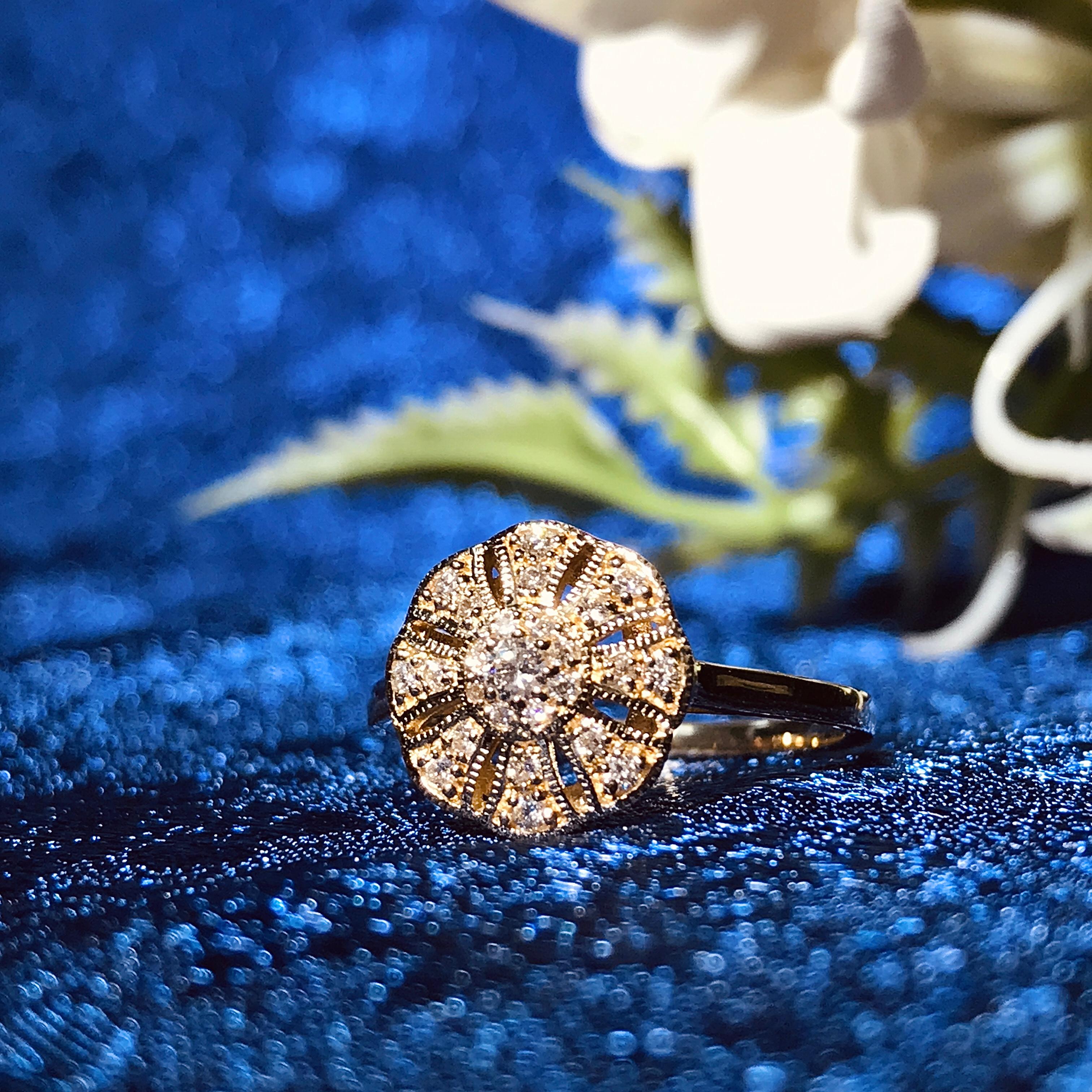 A lovely floral ring for anyone who loves antique-inspired jewelry. Made of diamonds set on 14k yellow gold. The twenty-five diamonds form a flower sit on the open worked floral motif for a beautifully feminine design that’s the perfect finishing