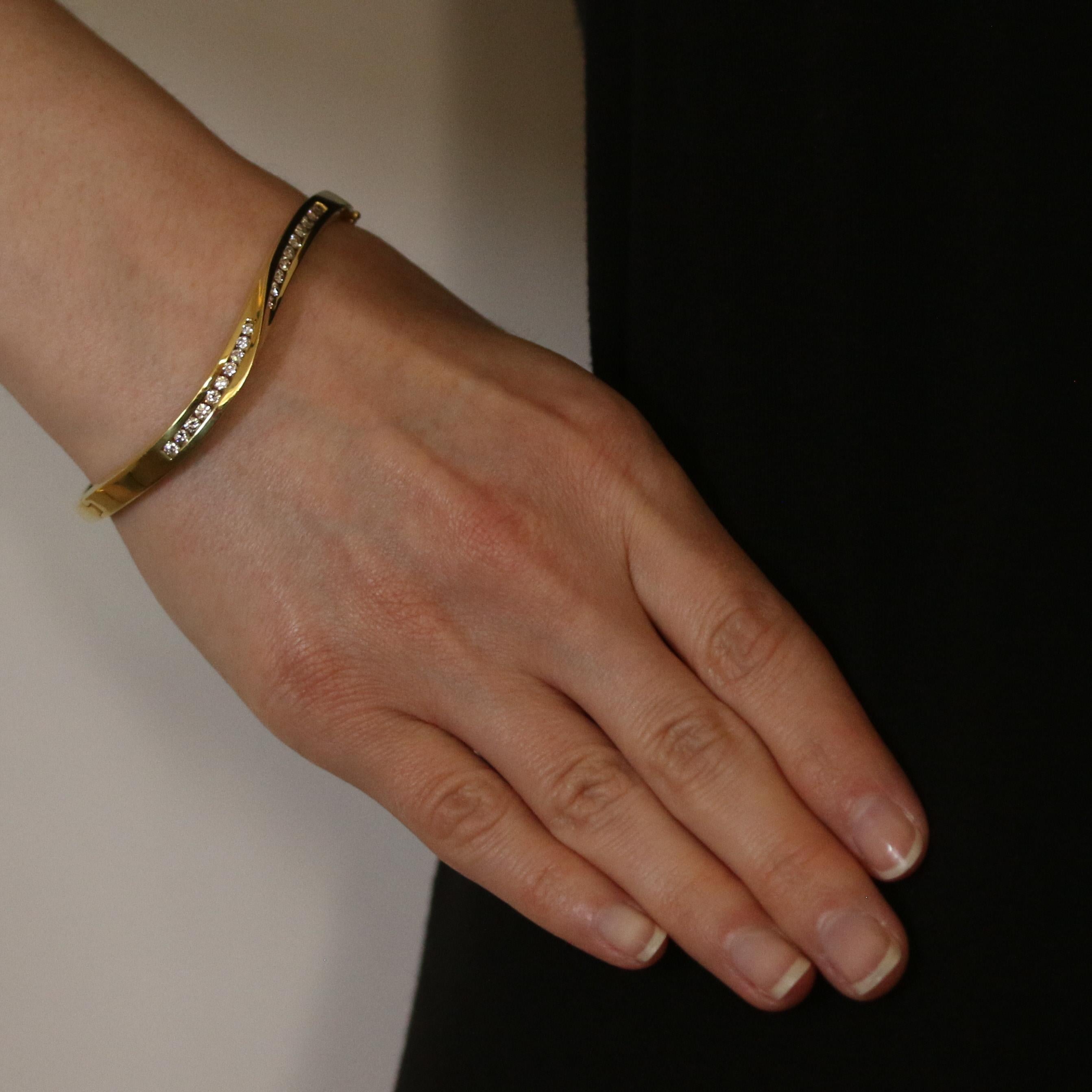 Zelebrieren Sie die Schönheit der fließenden Bewegung in der Zeit! Dieser ovale Armreif aus 18-karätigem Gelbgold zeigt ein skulpturales Wellendesign, das mit einer Reihe von weißen Diamanten funkelt.

Metallgehalt: Garantiert 18k Gold wie