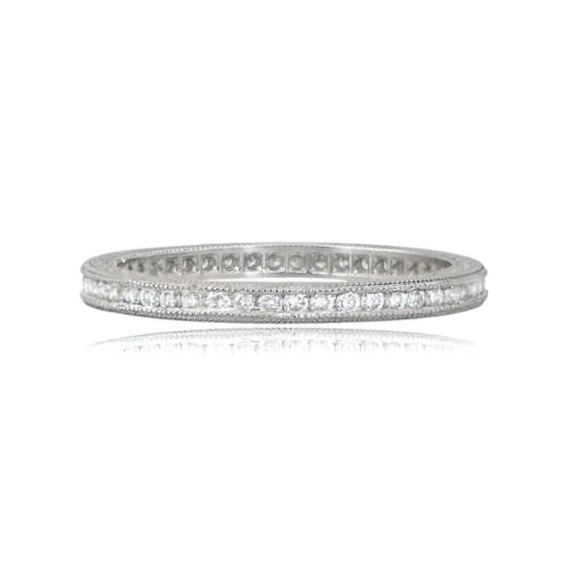 An exquisite vintage-style wedding band, inspired by the French Art Deco Era, featuring beautiful etchings along the sides. The diamonds are channel-set, boasting H color and VS2 clarity. Handcrafted in platinum, the band showcases a graceful width