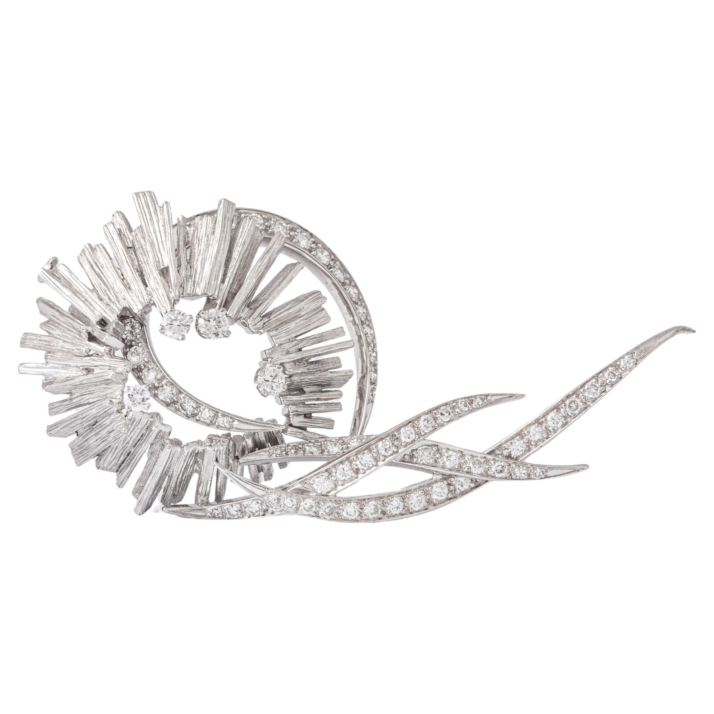 Diamond and white gold 18K Brooch stylized design.
66 diamonds. Total approximately 1.39 carats.
Circa 1960.
Total length: 6.00 centimeters.
Width: 0.10 centimeters up to 3.20 centimeters.

Total weight: 21.09 grams.