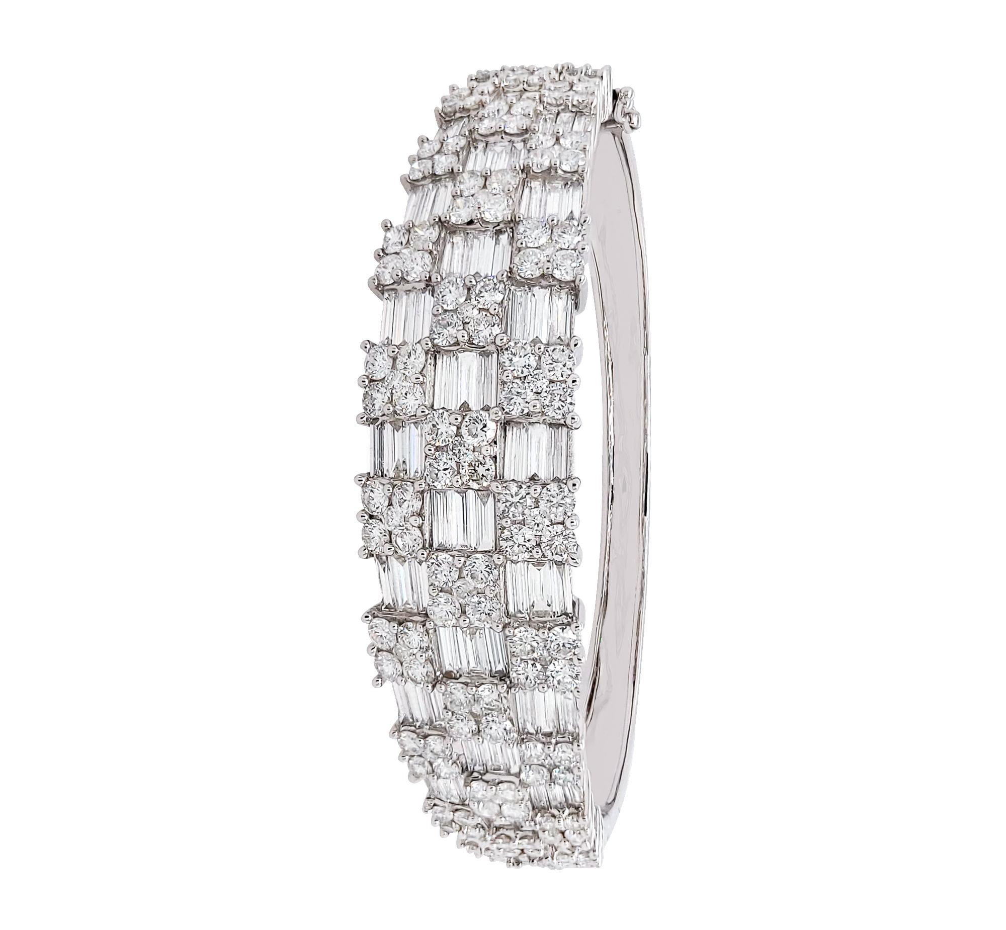 A beautiful bangle set half way with tapered baguette and round diamonds. 
The diamonds are set invisibly and are equivalent to F color, SI clarity.
Inner circumference is 6.5 ins (16.51 cm).
Metal is 18k white gold.
Gross weight is 20.58 grams.