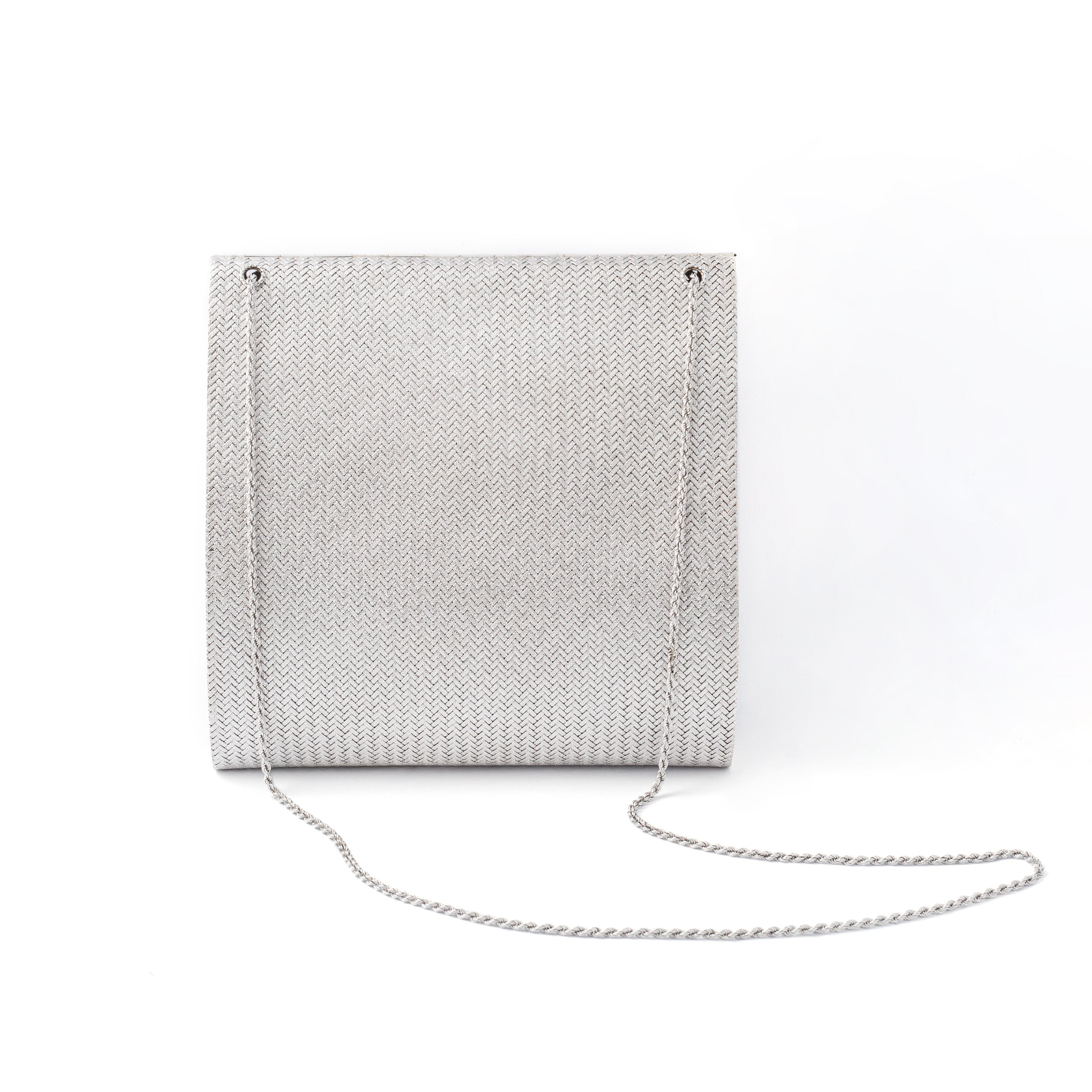 Diamond white gold evening bag. 
Interior includes a mirror. 
Circa 1980.

Total height: approx. 15.00 centimeters.
Total length: approx. 14.10 centimeters.
Total depth: approx. 1.50 centimeters up to 4.40 centimeters.
Total weight: 462.80