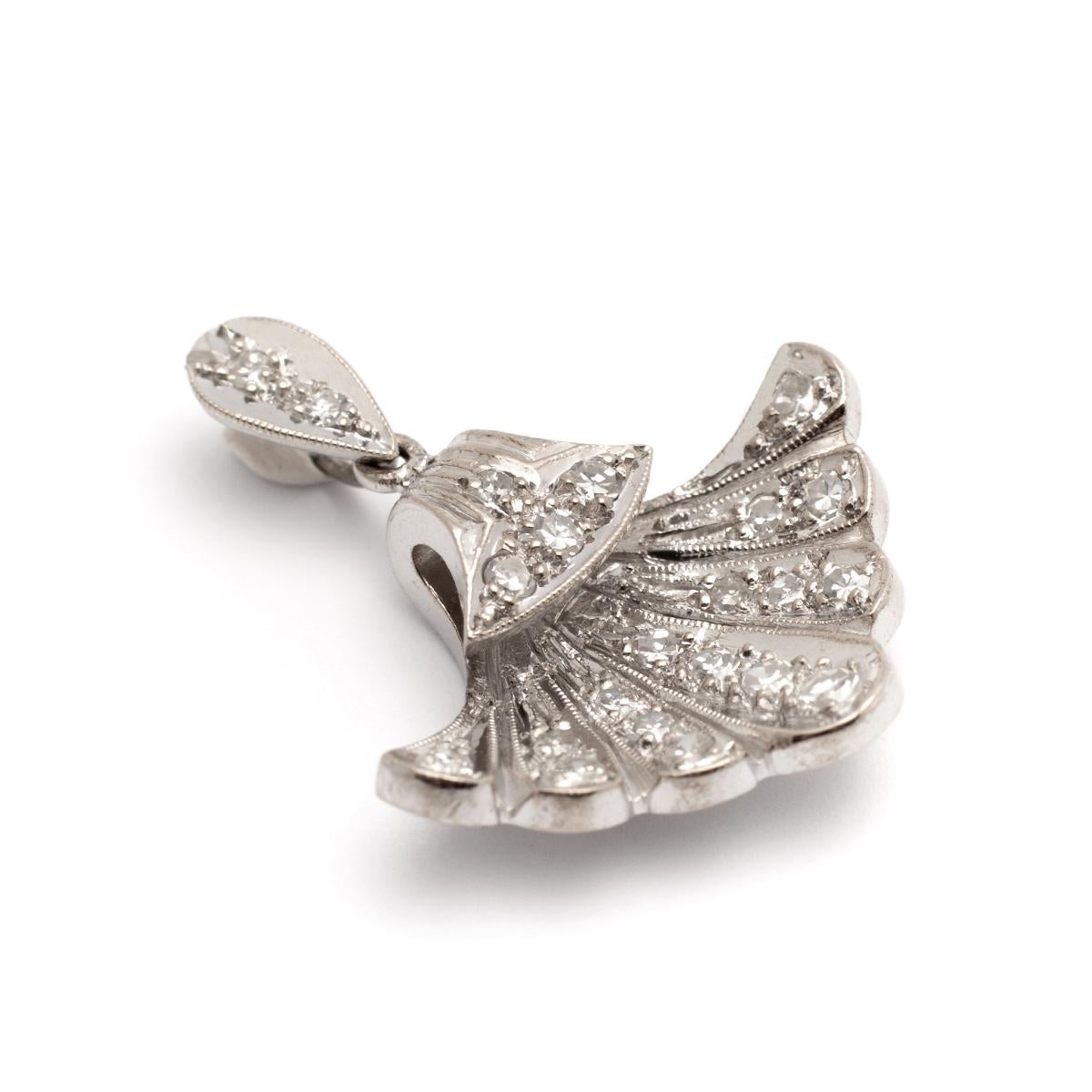 Ciondolo con diamante su oro bianco e platino che rappresenta una conchiglia.
Lunghezza: 2.50 centimetri.
Larghezza: 2.50 centimetri.
Peso lordo: 5,07 grammi.