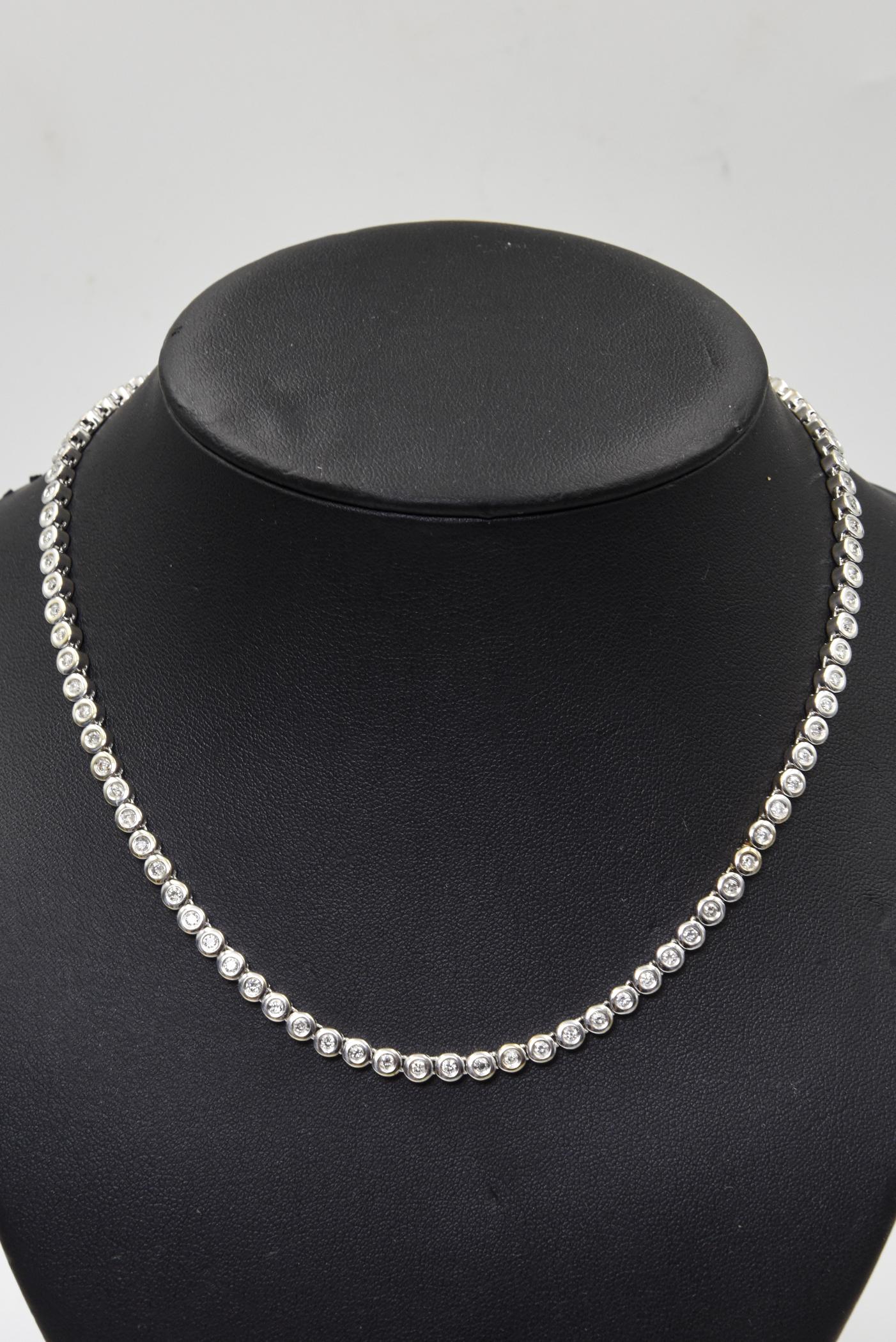 This necklace features 93 bezel set diamonds approximately .06 points each total diamond weight approximately 5.58. mounted in 14k white gold.  The approximate total diamond weight for the necklace is .  It has a push button clasp and a figure 