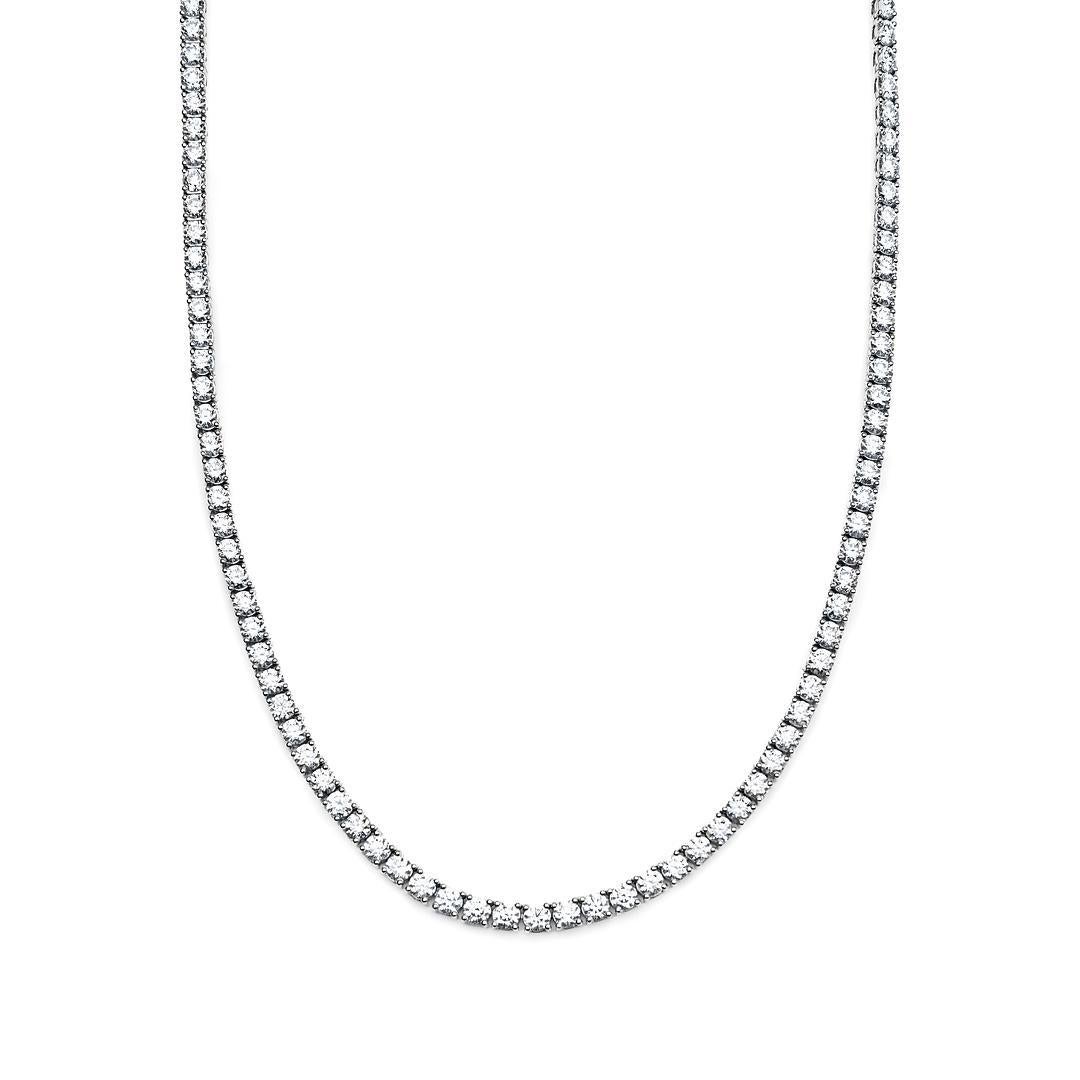 Introducing our White Gold Tennis Necklace with round diamonds, a timeless piece designed to grace your neckline with elegance and brilliance. 

The hallmark of this necklace is its classic tennis design, featuring a continuous line of round