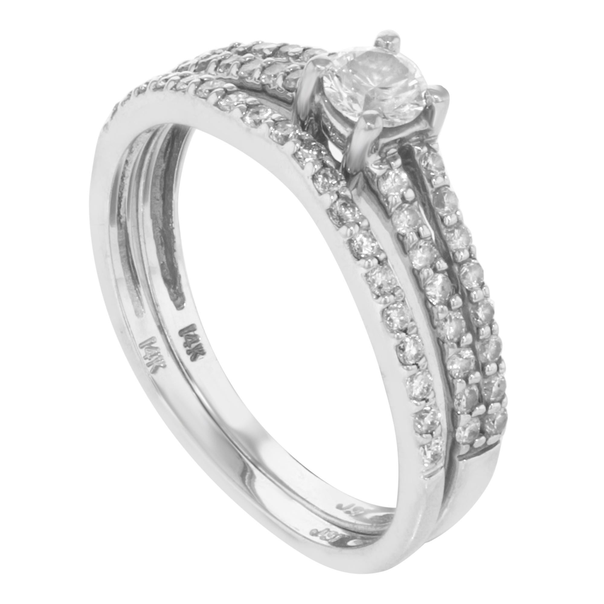 This stunning 2 piece set of rings is crafted in 14K white gold. Featuring center round cut diamond in prong setting with round cut accents stones in pave setting. Total diamond weight: 0.65 cttw. Size of the ring is 7. Total weight 3.2 g. Comes
